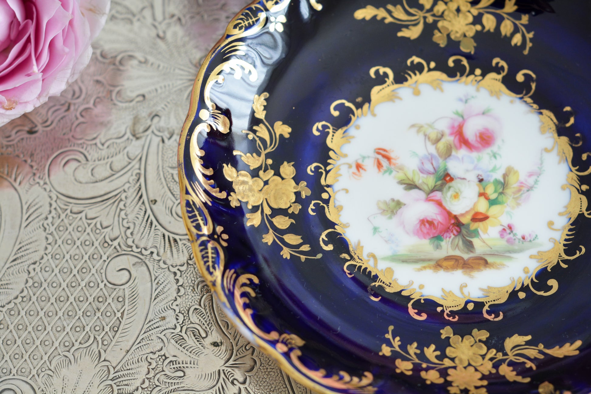 コールポートのロココリバイバル作品のアデレードシェイプ。とても優雅なシェイプで、ハンドペイントで描かれる花々は繊細でとても美しいです。いろいろなデザインが作られていて、シェイプは同じでも絵柄は少しずつ違います。こちらはコバルトブルーに金彩のお花模様が豪華なお品。アデレードシェイプは探すのにとても苦労しますが、見つけた時の喜びはとても大きいものです。金彩の薄れはありますが、貫入のないとても良い状態です。素敵なアデレードシェイプをぜひご覧ください。