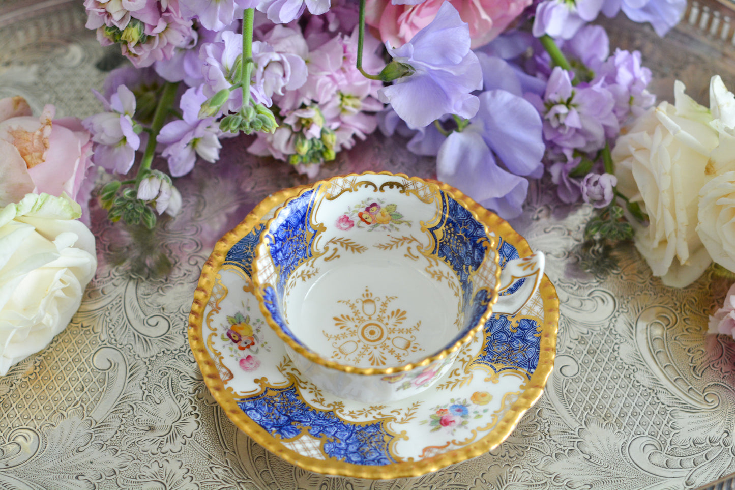 コールポートの人気シリーズ、バットウィングシリーズ。とても珍しい模様のデュオが入荷しました。鮮やかなブルーカラーの年輪のような模様がとても美しいお品です。カップのサイドにはエナメルのお花たちが描かれています。以前色違いの淡いグリーンをご紹介したことがあります。こちらは、カップに製造時にできたと思われる小さな穴があります。貫通はしていないのですが、そこだけ油薬がかかっていません。その穴付近にごく微細な貫入が1つあります。 その他は貫入もなく、金彩もとても綺麗に残っていて、キラキラと輝いています。特別なバットウィング。プレゼントにもご自身のご褒美にもぴったりなお品です。