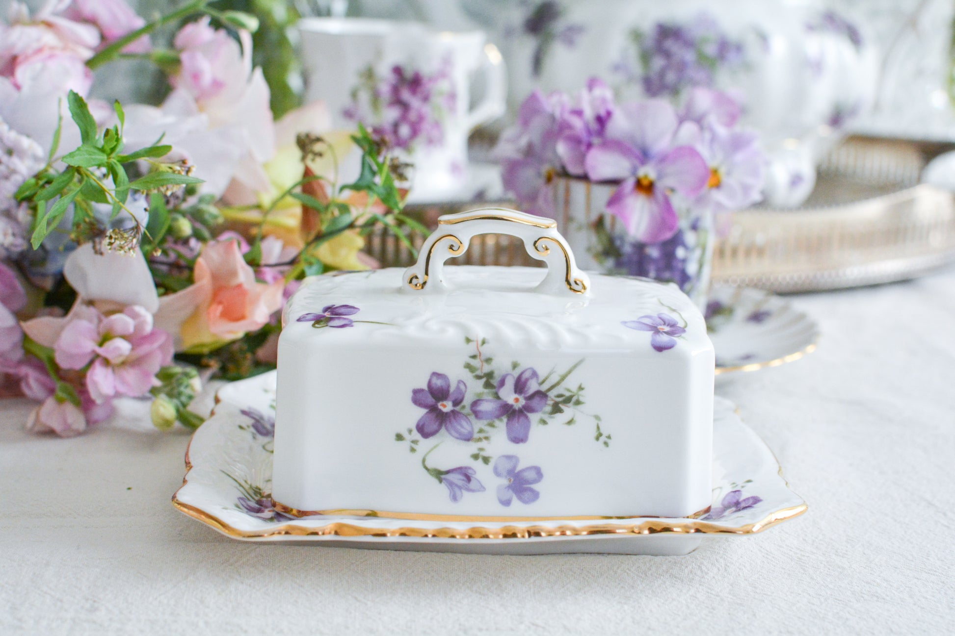 ハマースレイの人気シリーズ、ヴィクトリアンバイオレットシリーズ。珍しいバターディッシュです。お馴染みの可憐なすみれの模様が美しく、蓋の持ち手もハマースレイらしいとてもエレガントなデザイン。バターはもちろん、小さなお菓子を入れてゲストをおもてなししても素敵ですね。ティータイムを華やかに盛り上げてくれるアイテムです。