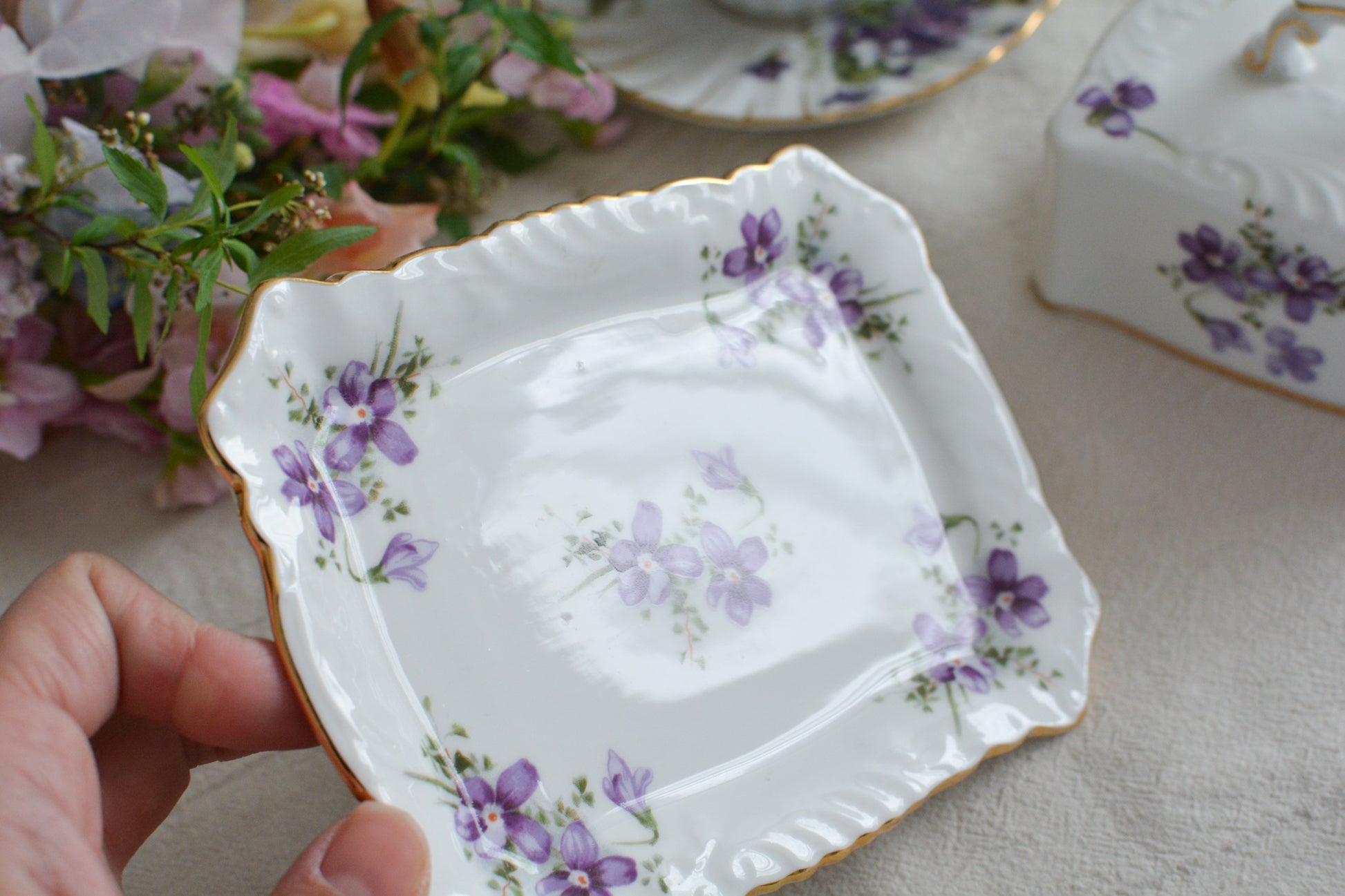 ハマースレイの人気シリーズ、ヴィクトリアンバイオレットシリーズ。珍しいバターディッシュです。お馴染みの可憐なすみれの模様が美しく、蓋の持ち手もハマースレイらしいとてもエレガントなデザイン。バターはもちろん、小さなお菓子を入れてゲストをおもてなししても素敵ですね。ティータイムを華やかに盛り上げてくれるアイテムです。