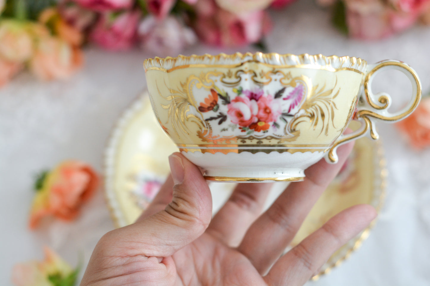 コールポートのペンブロークシェイプと呼ばれるシェイプのカップです。縁の飾り模様が特徴的で1820年代後半に作られたとても古い作品です。豪華な縁飾りに手描きで描かれた美しい花々、エレガントなリングハンドル。約200年前に作られ、この持ち主の貴族はこんな美しいカップでどんな優雅なティータイムを過ごしていたのでしょうか。