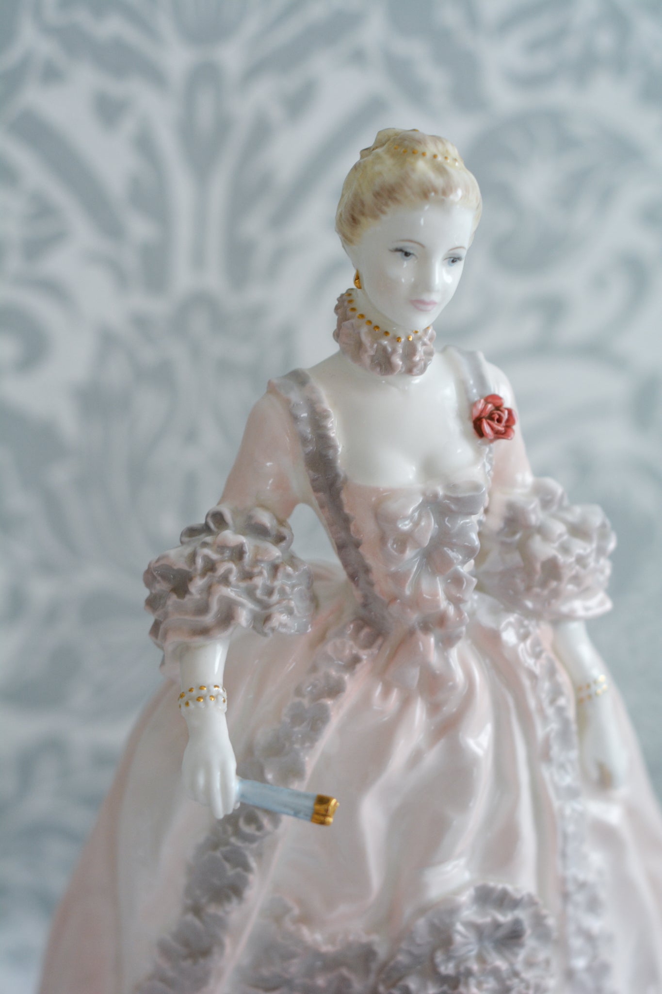 コールポートのポンパドール夫人の美しいフィギュリン。コールポートの中でも一番貴重で人気のフィギュリンではないでしょうか。美しいお顔にグレーとピンクの華やかなドレス。人気があるのも分かります。ポンパドール夫人はその美顔からフランスルイ15世の公式の愛妾となったのは有名な話。美顔だけでなく、頭もとてもよく政治にも積極的に関与しています。色々な側面を持ち合わせますが、芸術を愛し、その発展に大きな影響を与えました。ポンパドール夫人の時代はフランスを中心に優美なロココ様式が流行します。イギリスで1810年〜1830年代頃に流行したロココリバイバルはフランスのロココ様式の影響を受けてイギリスでロココ様式が再流行したものです。そんなポンパドール夫人のフィギュリンは、キャビネットに飾ってもティータイムにテーブルに置いてもどんなシーンでも、パッとスポットライトが当たったかのような存在感です。