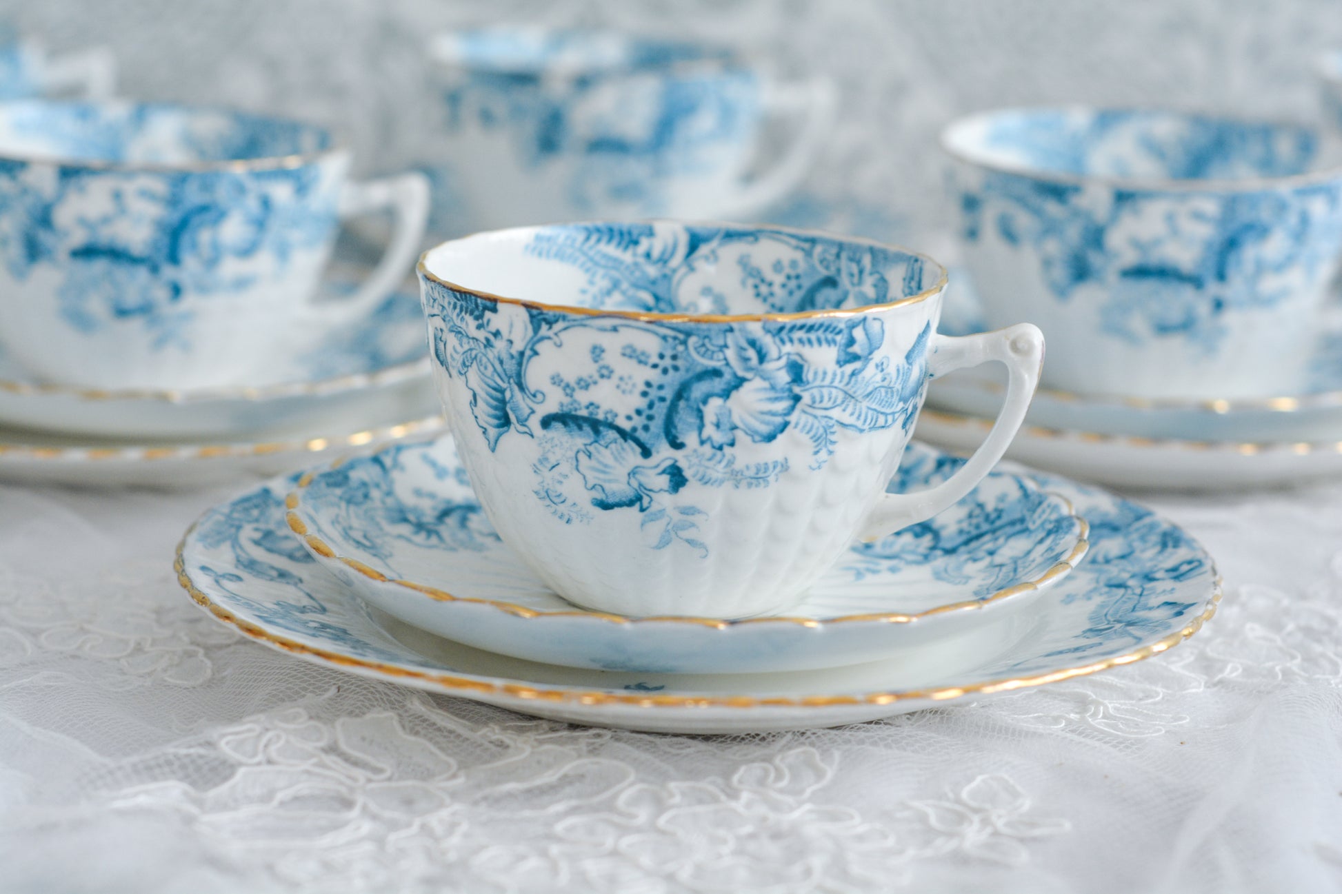 サミュエル・ラドフォードというメーカーの可愛らしいティートリオです。サミュエル・ラドフォードはスタッフォードシャーのメーカーで、1879年から1957年まで創業していました。こちらはブルーの転写模様がとても美しく地模様もとても可愛らしいお品です。同じパターンのミルクジャグ&シュガーボウル、色違いのデザートプレートも別で掲載しています。  こちらは1セットの価格です。全部で6セットあります。状態の良いものからお送りします。