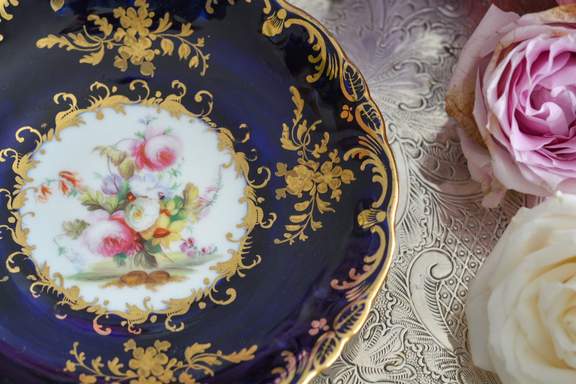 コールポートのロココリバイバル作品のアデレードシェイプ。とても優雅なシェイプで、ハンドペイントで描かれる花々は繊細でとても美しいです。いろいろなデザインが作られていて、シェイプは同じでも絵柄は少しずつ違います。こちらはコバルトブルーに金彩のお花模様が豪華なお品。アデレードシェイプは探すのにとても苦労しますが、見つけた時の喜びはとても大きいものです。金彩の薄れはありますが、貫入のないとても良い状態です。素敵なアデレードシェイプをぜひご覧ください。