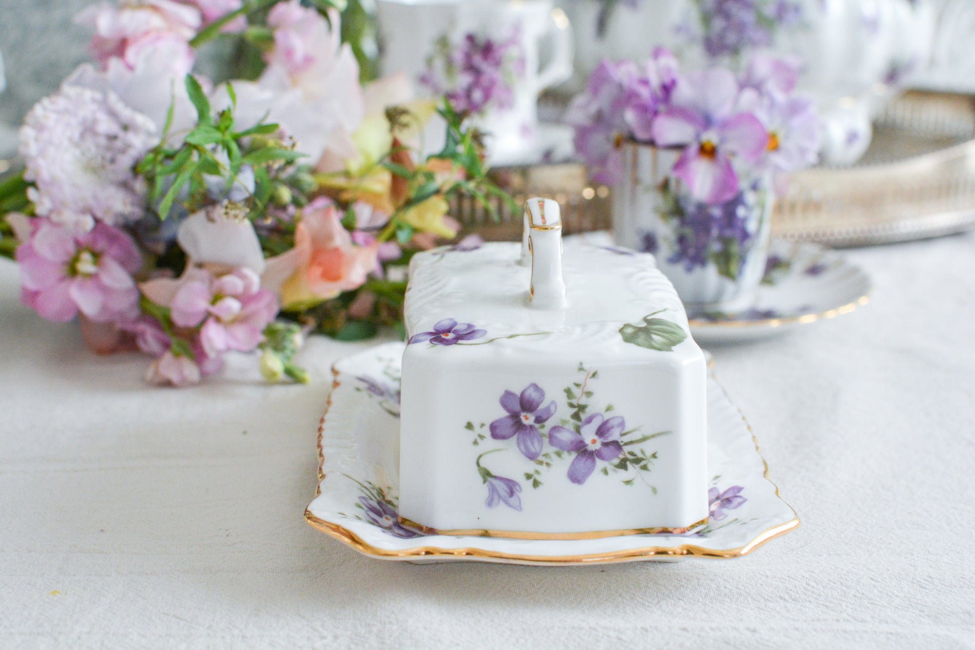 ハマースレイの人気シリーズ、ヴィクトリアンバイオレットシリーズ。珍しいバターディッシュです。お馴染みの可憐なすみれの模様が美しく、蓋の持ち手もハマースレイらしいとてもエレガントなデザイン。バターはもちろん、小さなお菓子を入れてゲストをおもてなししても素敵ですね。ティータイムを華やかに盛り上げてくれるアイテムです。