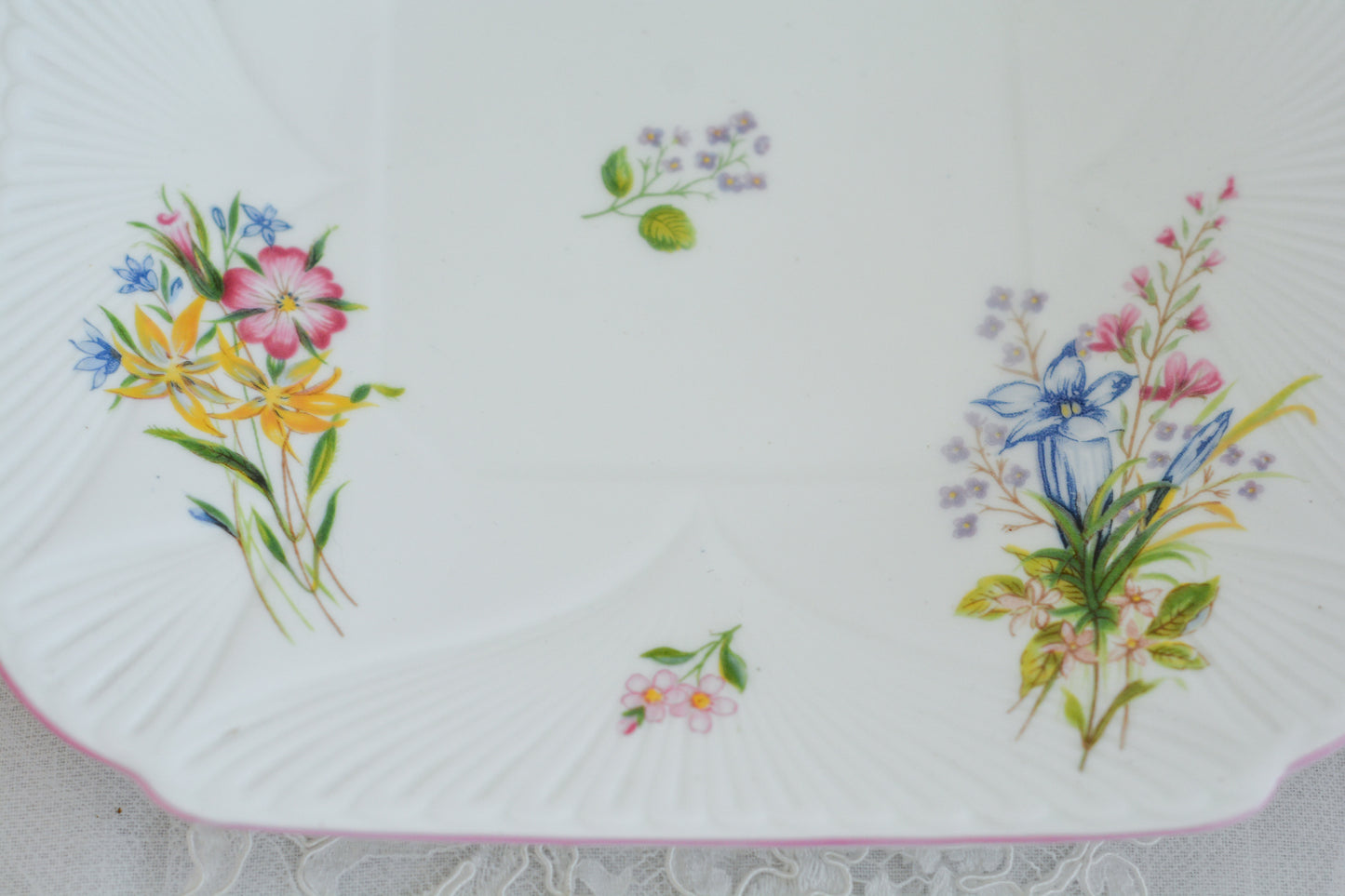 シェリーのワイルドフラワーシリーズの可愛らしいB&Bプレート(ブレッド&バタープレート)。イギリスの色とりどりの野花が散りばめられていて、パステルピンクの縁取りとハンドルがとても可愛らしいお品です。B&Bプレートの「B&B」は「ブレッド&バター」のことでパンやお菓子を盛り付けるのに便利なプレートです。