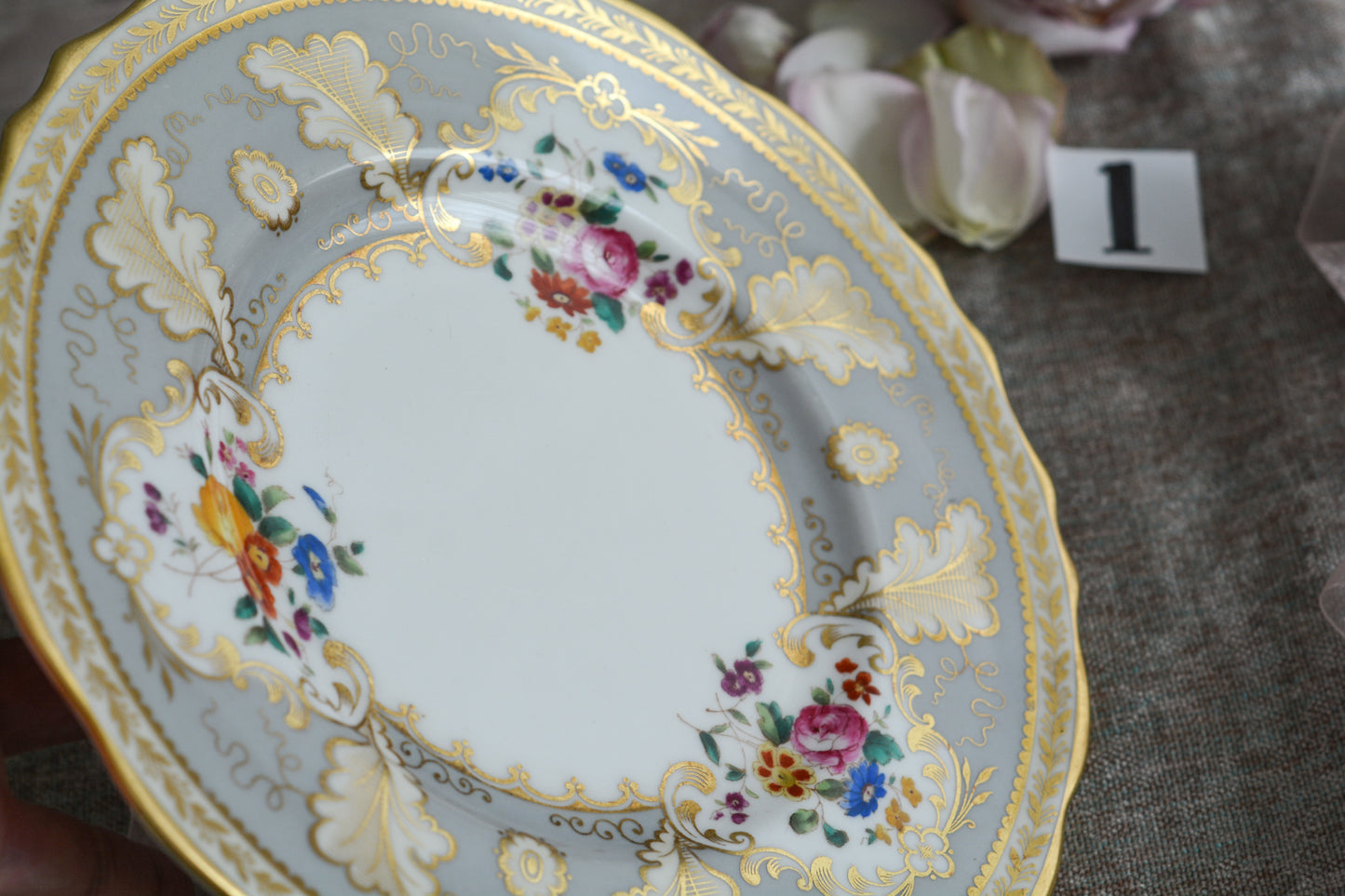 コウルドンのティファニーパターンの素敵なデザートプレートです。ハロッズがオーダーしたもので、ティファニーのスタンプはありませんが、柄はティファニーがコウルドンに特注したパターンです。ティファニーらしい上品な絵柄がとても美しくでコウルドンの中でも人気のシリーズです。当時も人気があったのでしょう。いろいろな小売店がこのパターンをオーダーしています。グレーカラーは柔らかい雰囲気で金彩との相性もいいです。とてもエレガントなプレートです。