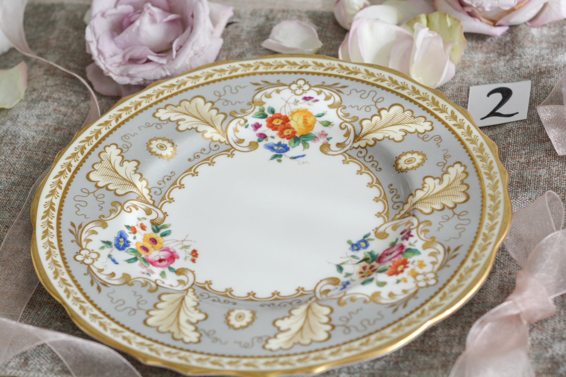 コウルドンのティファニーパターンの素敵なデザートプレートです。ハロッズがオーダーしたもので、ティファニーのスタンプはありませんが、柄はティファニーがコウルドンに特注したパターンです。ティファニーらしい上品な絵柄がとても美しくでコウルドンの中でも人気のシリーズです。当時も人気があったのでしょう。いろいろな小売店がこのパターンをオーダーしています。グレーカラーは柔らかい雰囲気で金彩との相性もいいです。とてもエレガントなプレートです。