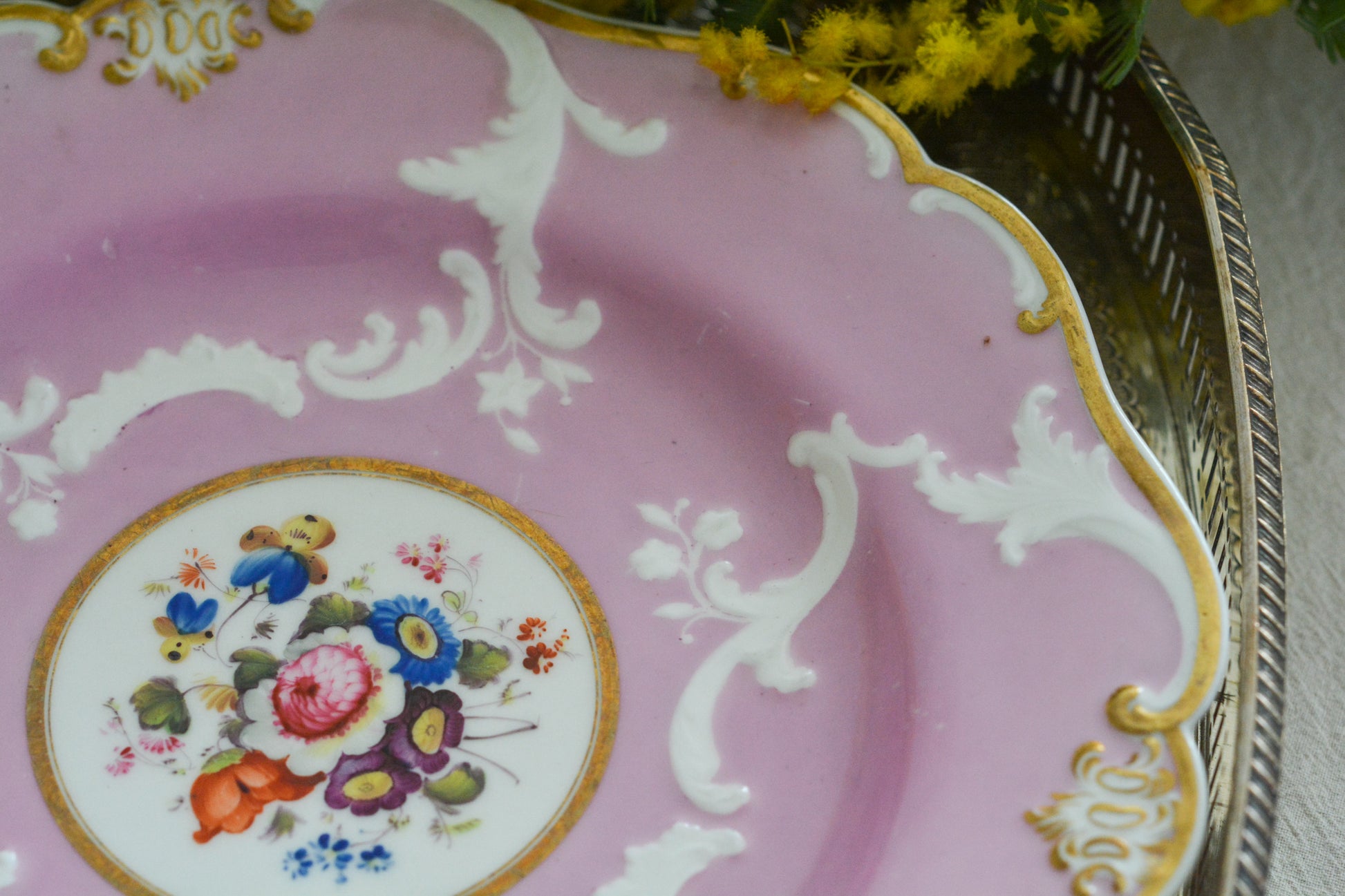 可愛らしいピンクカラーに中央にハンドペイントで丁寧に描かれたブーケの模様が美しいプレートです。エンボスの模様も優雅でチョコレートや小さな焼き菓子、パンどんなものを盛り付けても品よくまとまりそうです。一ヶ所小さなヘアラインがあるためお値打ち価格になっています。