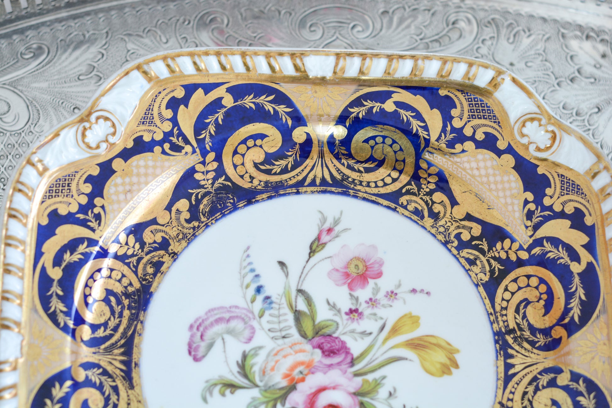 スポードのコバルトブルー地に豪華な金彩模様と手描きで描かれたブーケの模様が美しいプレートです。ちょっと珍しい形をしています。縁の縁飾りのような模様もとても素敵ですね。裏面にはバックスタンプではなく手描きでSpodeと記されています。とても豪華なプレートでキャビネットプレートとして飾ってもとても素敵だなと思います。