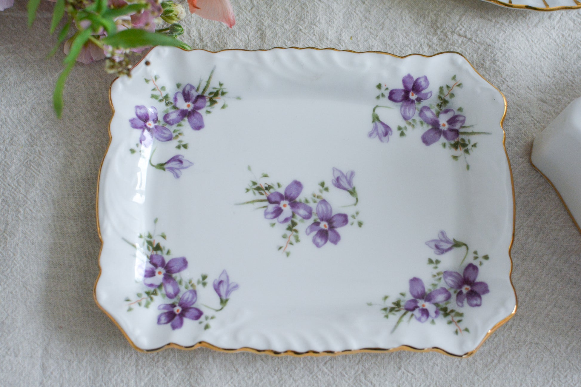 ハマースレイの人気シリーズ、ヴィクトリアンバイオレットシリーズ。珍しいバターディッシュです。お馴染みの可憐なすみれの模様が美しく、蓋の持ち手もハマースレイらしいとてもエレガントなデザイン。バターはもちろん、小さなお菓子を入れてゲストをおもてなししても素敵ですね。ティータイムを華やかに盛り上げてくれるアイテムです。