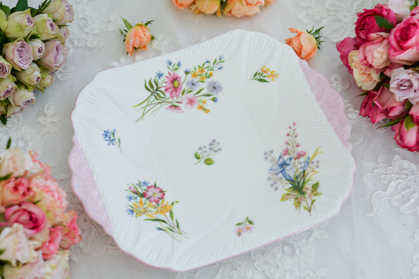 シェリーのワイルドフラワーシリーズの可愛らしいB&Bプレート(ブレッド&バタープレート)。イギリスの色とりどりの野花が散りばめられていて、パステルピンクの縁取りとハンドルがとても可愛らしいお品です。B&Bプレートの「B&B」は「ブレッド&バター」のことでパンやお菓子を盛り付けるのに便利なプレートです。