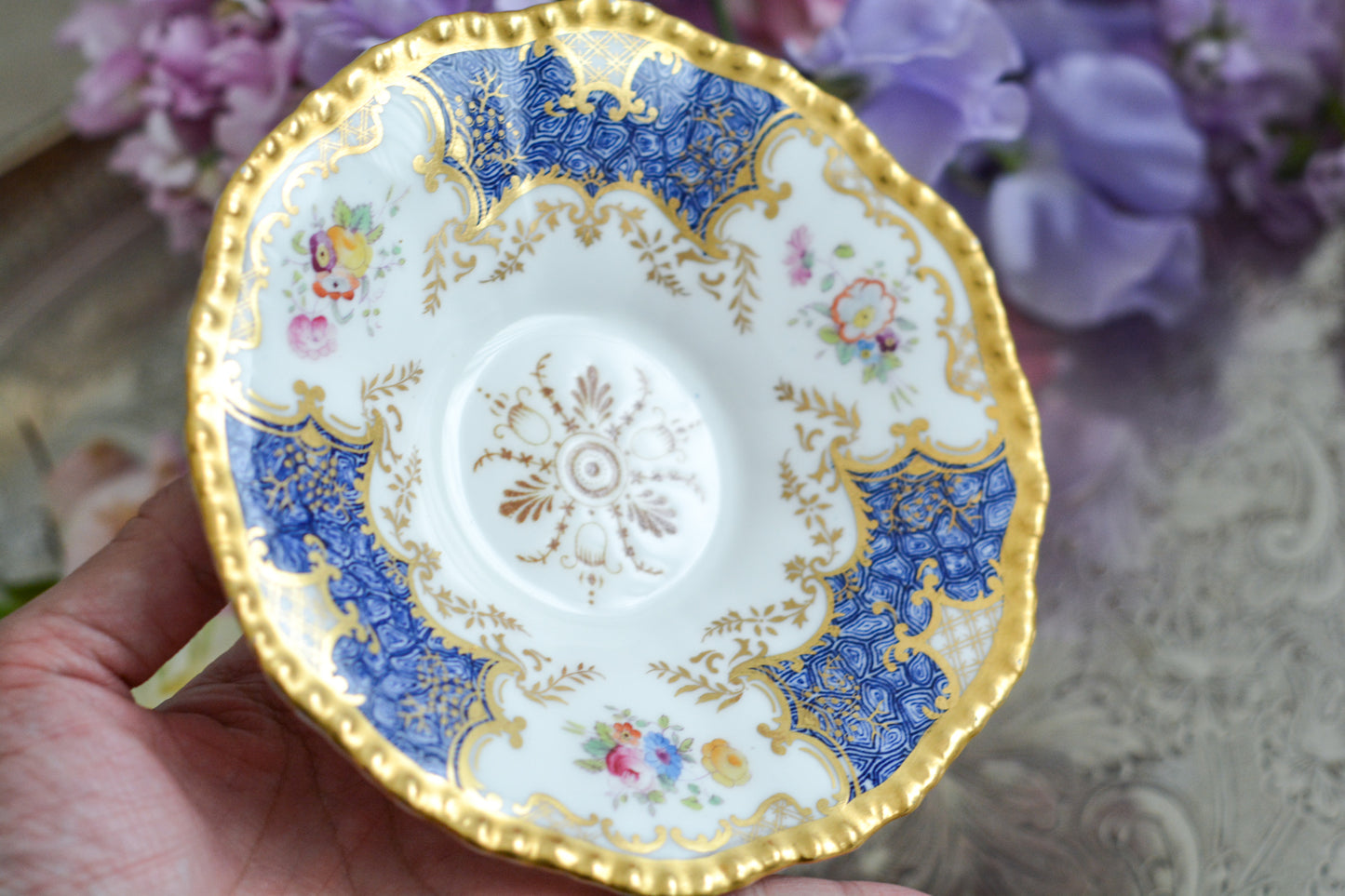 コールポートの人気シリーズ、バットウィングシリーズ。とても珍しい模様のデュオが入荷しました。鮮やかなブルーカラーの年輪のような模様がとても美しいお品です。カップのサイドにはエナメルのお花たちが描かれています。以前色違いの淡いグリーンをご紹介したことがあります。こちらは、カップに製造時にできたと思われる小さな穴があります。貫通はしていないのですが、そこだけ油薬がかかっていません。その穴付近にごく微細な貫入が1つあります。 その他は貫入もなく、金彩もとても綺麗に残っていて、キラキラと輝いています。特別なバットウィング。プレゼントにもご自身のご褒美にもぴったりなお品です。