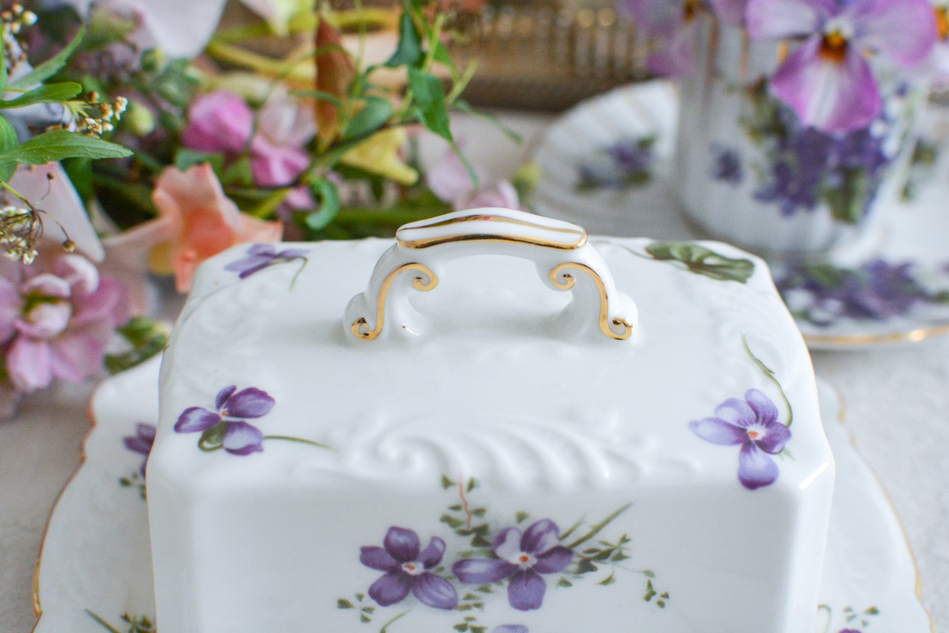 ハマースレイの人気シリーズ、ヴィクトリアンバイオレットシリーズ。珍しいバターディッシュです。お馴染みの可憐なすみれの模様が美しく、蓋の持ち手もハマースレイらしいとてもエレガントなデザイン。バターはもちろん、小さなお菓子を入れてゲストをおもてなししても素敵ですね。ティータイムを華やかに盛り上げてくれるアイテムです。