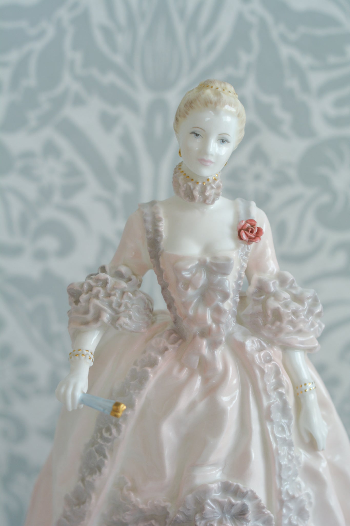 コールポートのポンパドール夫人の美しいフィギュリン。コールポートの中でも一番貴重で人気のフィギュリンではないでしょうか。美しいお顔にグレーとピンクの華やかなドレス。人気があるのも分かります。ポンパドール夫人はその美顔からフランスルイ15世の公式の愛妾となったのは有名な話。美顔だけでなく、頭もとてもよく政治にも積極的に関与しています。色々な側面を持ち合わせますが、芸術を愛し、その発展に大きな影響を与えました。ポンパドール夫人の時代はフランスを中心に優美なロココ様式が流行します。イギリスで1810年〜1830年代頃に流行したロココリバイバルはフランスのロココ様式の影響を受けてイギリスでロココ様式が再流行したものです。そんなポンパドール夫人のフィギュリンは、キャビネットに飾ってもティータイムにテーブルに置いてもどんなシーンでも、パッとスポットライトが当たったかのような存在感です。