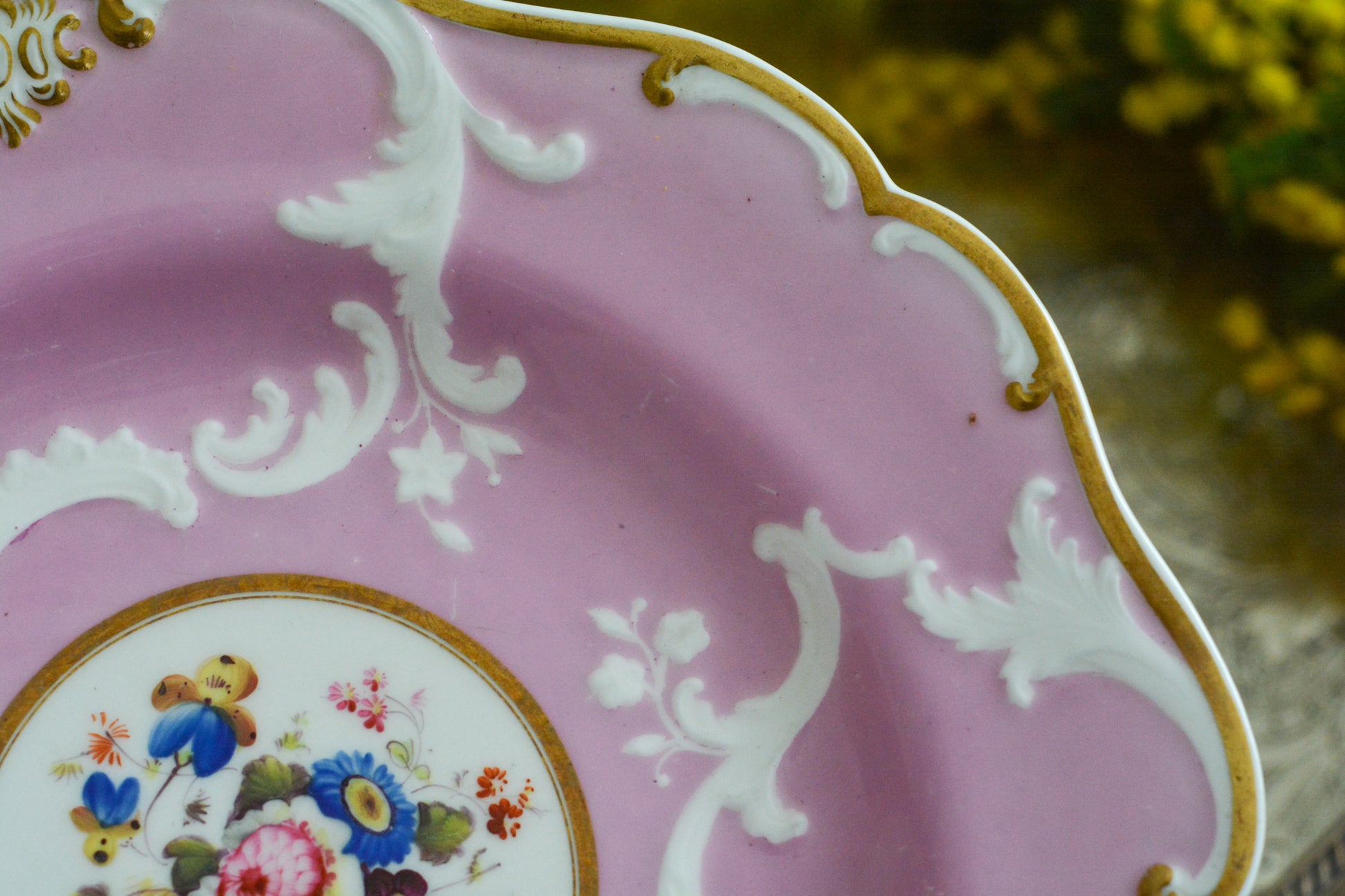 可愛らしいピンクカラーに中央にハンドペイントで丁寧に描かれたブーケの模様が美しいプレートです。エンボスの模様も優雅でチョコレートや小さな焼き菓子、パンどんなものを盛り付けても品よくまとまりそうです。一ヶ所小さなヘアラインがあるためお値打ち価格になっています。