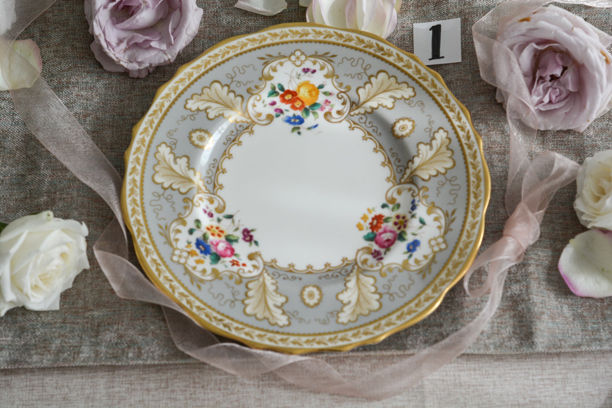 コウルドンのティファニーパターンの素敵なデザートプレートです。ハロッズがオーダーしたもので、ティファニーのスタンプはありませんが、柄はティファニーがコウルドンに特注したパターンです。ティファニーらしい上品な絵柄がとても美しくでコウルドンの中でも人気のシリーズです。当時も人気があったのでしょう。いろいろな小売店がこのパターンをオーダーしています。グレーカラーは柔らかい雰囲気で金彩との相性もいいです。とてもエレガントなプレートです。