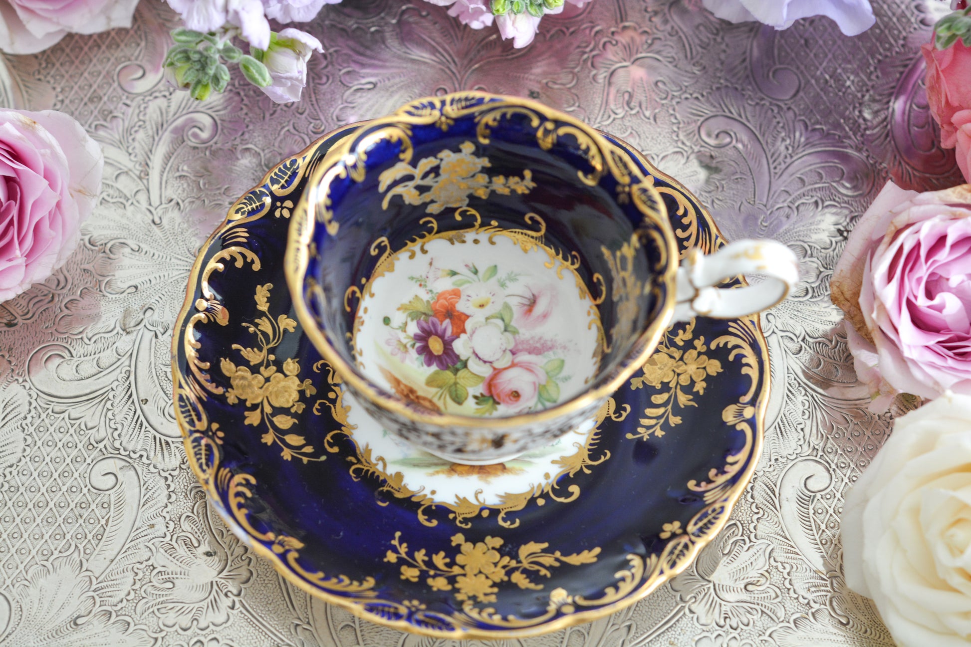 コールポートのロココリバイバル作品のアデレードシェイプ。とても優雅なシェイプで、ハンドペイントで描かれる花々は繊細でとても美しいです。いろいろなデザインが作られていて、シェイプは同じでも絵柄は少しずつ違います。こちらはコバルトブルーに金彩のお花模様が豪華なお品。アデレードシェイプは探すのにとても苦労しますが、見つけた時の喜びはとても大きいものです。金彩の薄れはありますが、貫入のないとても良い状態です。素敵なアデレードシェイプをぜひご覧ください。