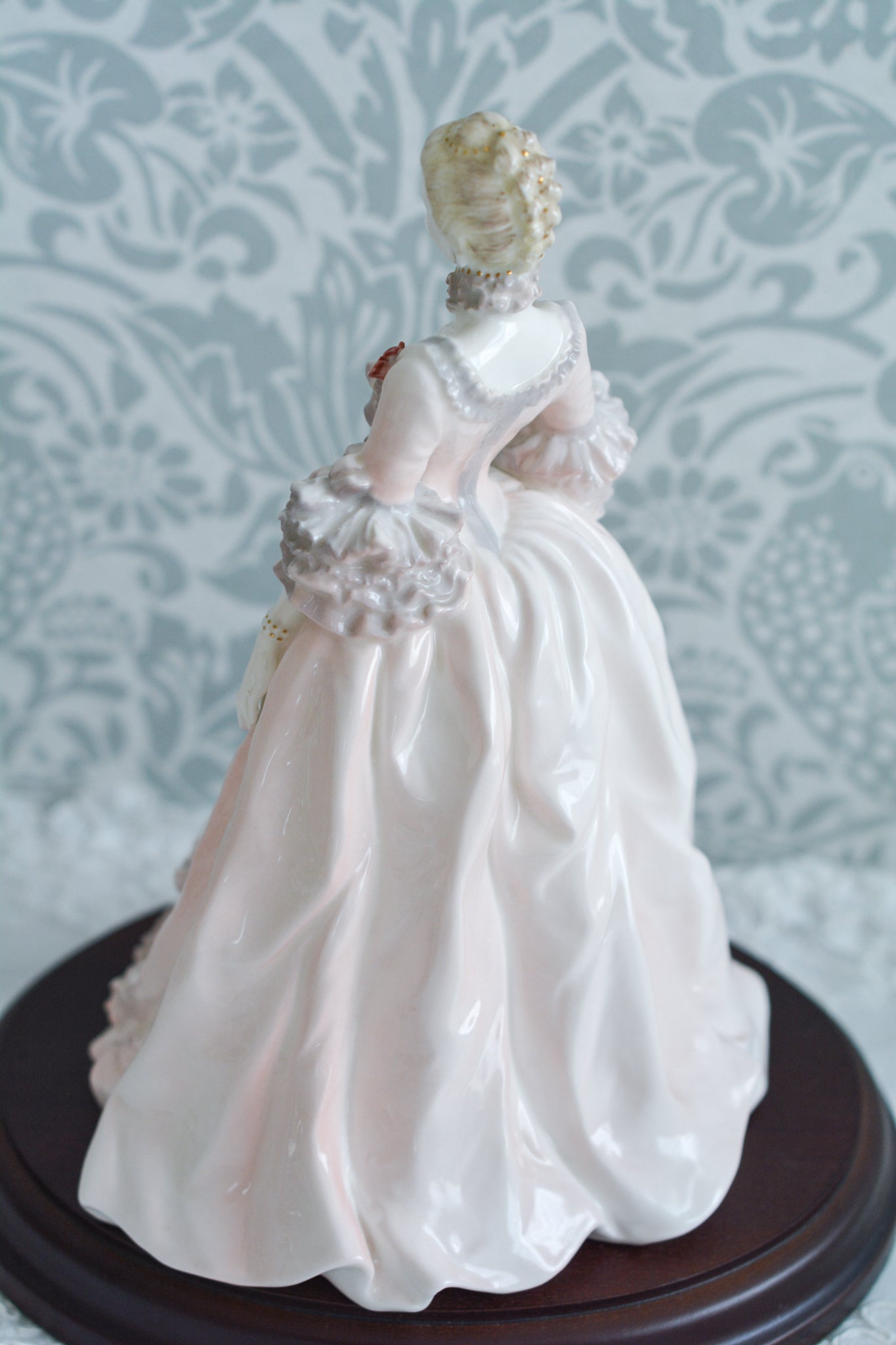 コールポートのポンパドール夫人の美しいフィギュリン。コールポートの中でも一番貴重で人気のフィギュリンではないでしょうか。美しいお顔にグレーとピンクの華やかなドレス。人気があるのも分かります。ポンパドール夫人はその美顔からフランスルイ15世の公式の愛妾となったのは有名な話。美顔だけでなく、頭もとてもよく政治にも積極的に関与しています。色々な側面を持ち合わせますが、芸術を愛し、その発展に大きな影響を与えました。ポンパドール夫人の時代はフランスを中心に優美なロココ様式が流行します。イギリスで1810年〜1830年代頃に流行したロココリバイバルはフランスのロココ様式の影響を受けてイギリスでロココ様式が再流行したものです。そんなポンパドール夫人のフィギュリンは、キャビネットに飾ってもティータイムにテーブルに置いてもどんなシーンでも、パッとスポットライトが当たったかのような存在感です。