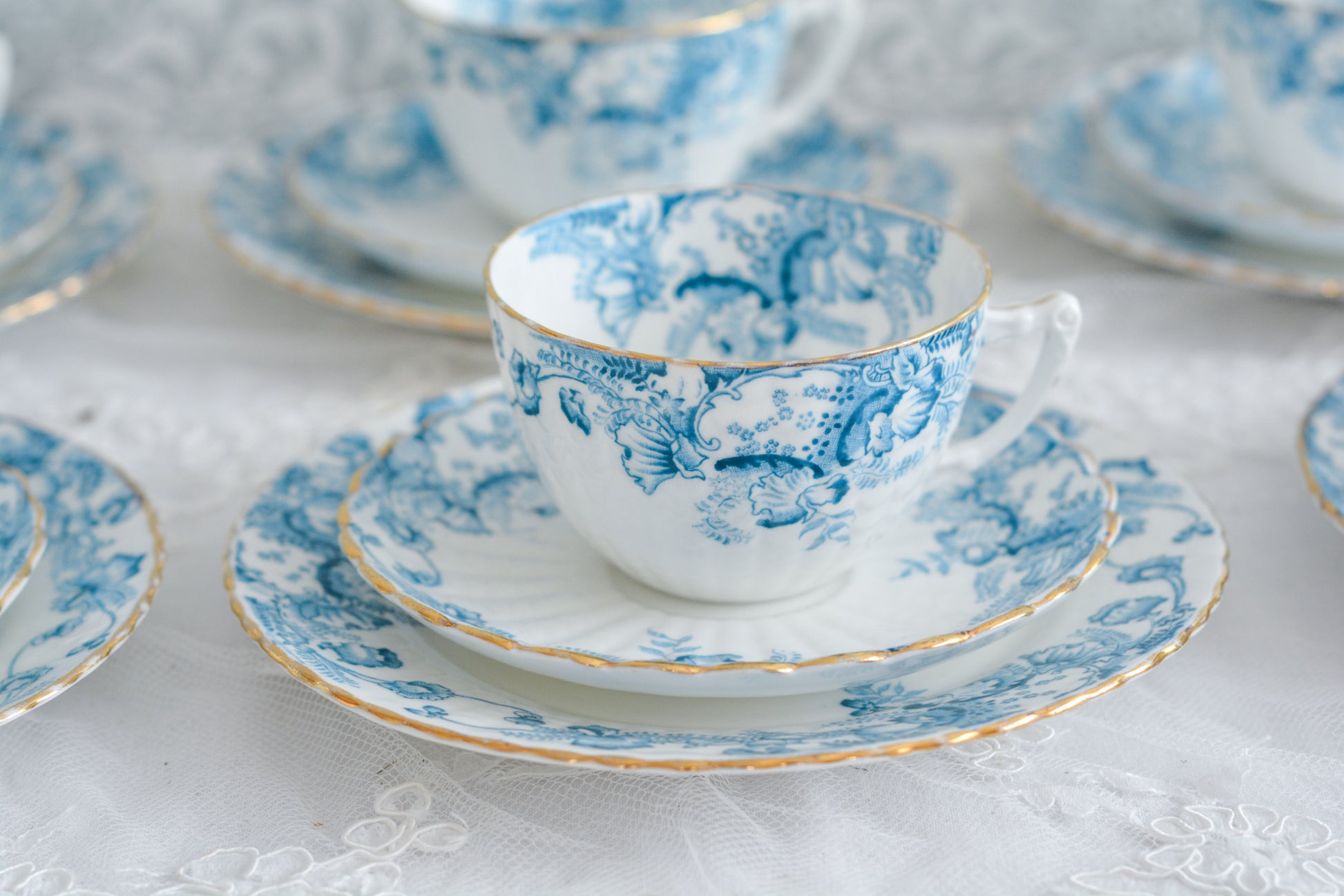 サミュエル・ラドフォードというメーカーの可愛らしいティートリオです。サミュエル・ラドフォードはスタッフォードシャーのメーカーで、1879年から1957年まで創業していました。こちらはブルーの転写模様がとても美しく地模様もとても可愛らしいお品です。同じパターンのミルクジャグ&シュガーボウル、色違いのデザートプレートも別で掲載しています。  こちらは1セットの価格です。全部で6セットあります。状態の良いものからお送りします。