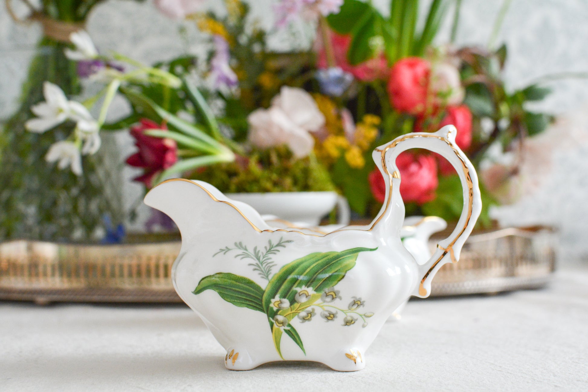 ハマースレイのスズランの絵柄が可愛らしいシュガー入れとミルクジャグ。このスズランのシリーズは人気がありますが、ヴィクトリアンバイオレットよりも生産数が少ないのか、なかなか見つかりません。優美なシェイプと美しいスズランの模様がとてもマッチしていて素敵なお品です。こちらはシュガー入れとミルクジャグの2点セットです。