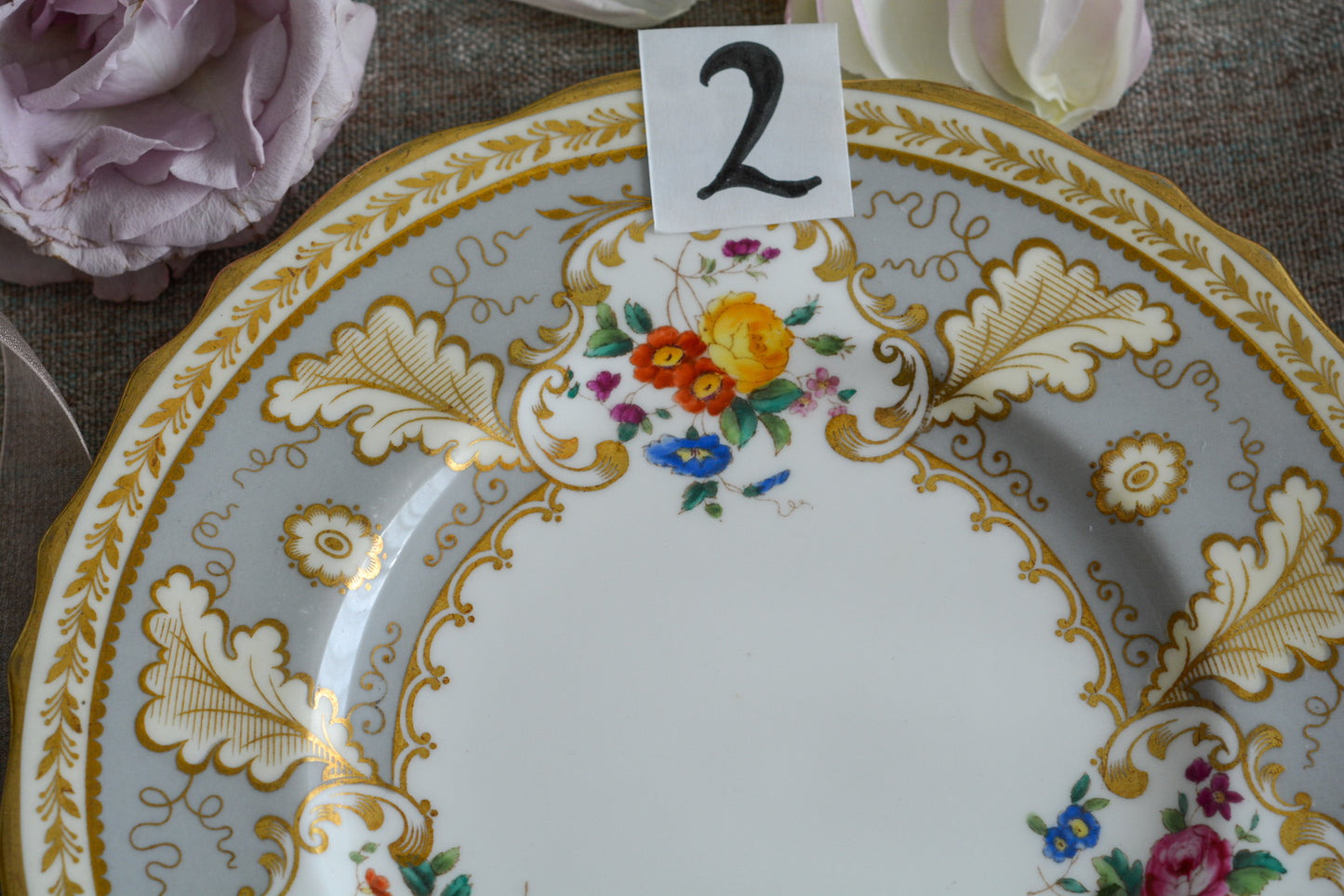 コウルドンのティファニーパターンの素敵なデザートプレートです。ハロッズがオーダーしたもので、ティファニーのスタンプはありませんが、柄はティファニーがコウルドンに特注したパターンです。ティファニーらしい上品な絵柄がとても美しくでコウルドンの中でも人気のシリーズです。当時も人気があったのでしょう。いろいろな小売店がこのパターンをオーダーしています。グレーカラーは柔らかい雰囲気で金彩との相性もいいです。とてもエレガントなプレートです。