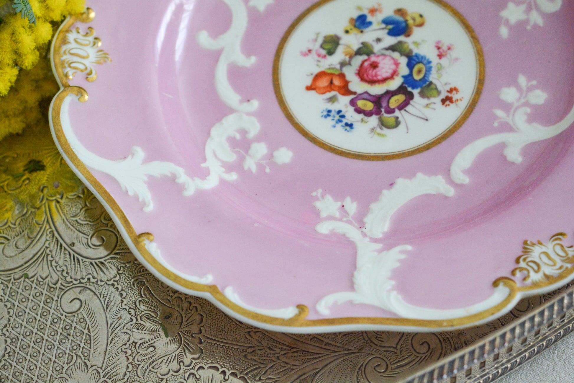 可愛らしいピンクカラーに中央にハンドペイントで丁寧に描かれたブーケの模様が美しいプレートです。エンボスの模様も優雅でチョコレートや小さな焼き菓子、パンどんなものを盛り付けても品よくまとまりそうです。一ヶ所小さなヘアラインがあるためお値打ち価格になっています。