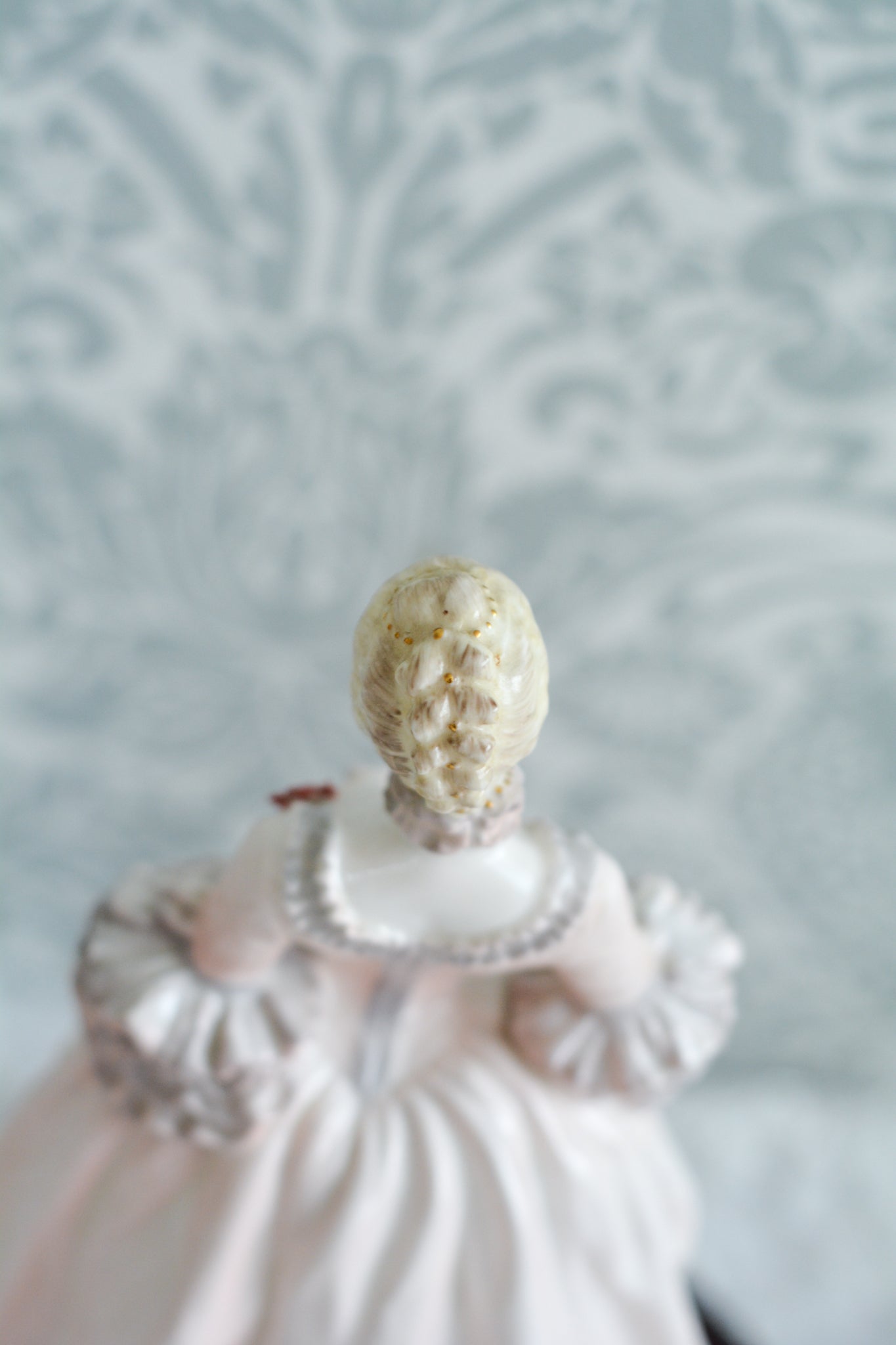 コールポートのポンパドール夫人の美しいフィギュリン。コールポートの中でも一番貴重で人気のフィギュリンではないでしょうか。美しいお顔にグレーとピンクの華やかなドレス。人気があるのも分かります。ポンパドール夫人はその美顔からフランスルイ15世の公式の愛妾となったのは有名な話。美顔だけでなく、頭もとてもよく政治にも積極的に関与しています。色々な側面を持ち合わせますが、芸術を愛し、その発展に大きな影響を与えました。ポンパドール夫人の時代はフランスを中心に優美なロココ様式が流行します。イギリスで1810年〜1830年代頃に流行したロココリバイバルはフランスのロココ様式の影響を受けてイギリスでロココ様式が再流行したものです。そんなポンパドール夫人のフィギュリンは、キャビネットに飾ってもティータイムにテーブルに置いてもどんなシーンでも、パッとスポットライトが当たったかのような存在感です。