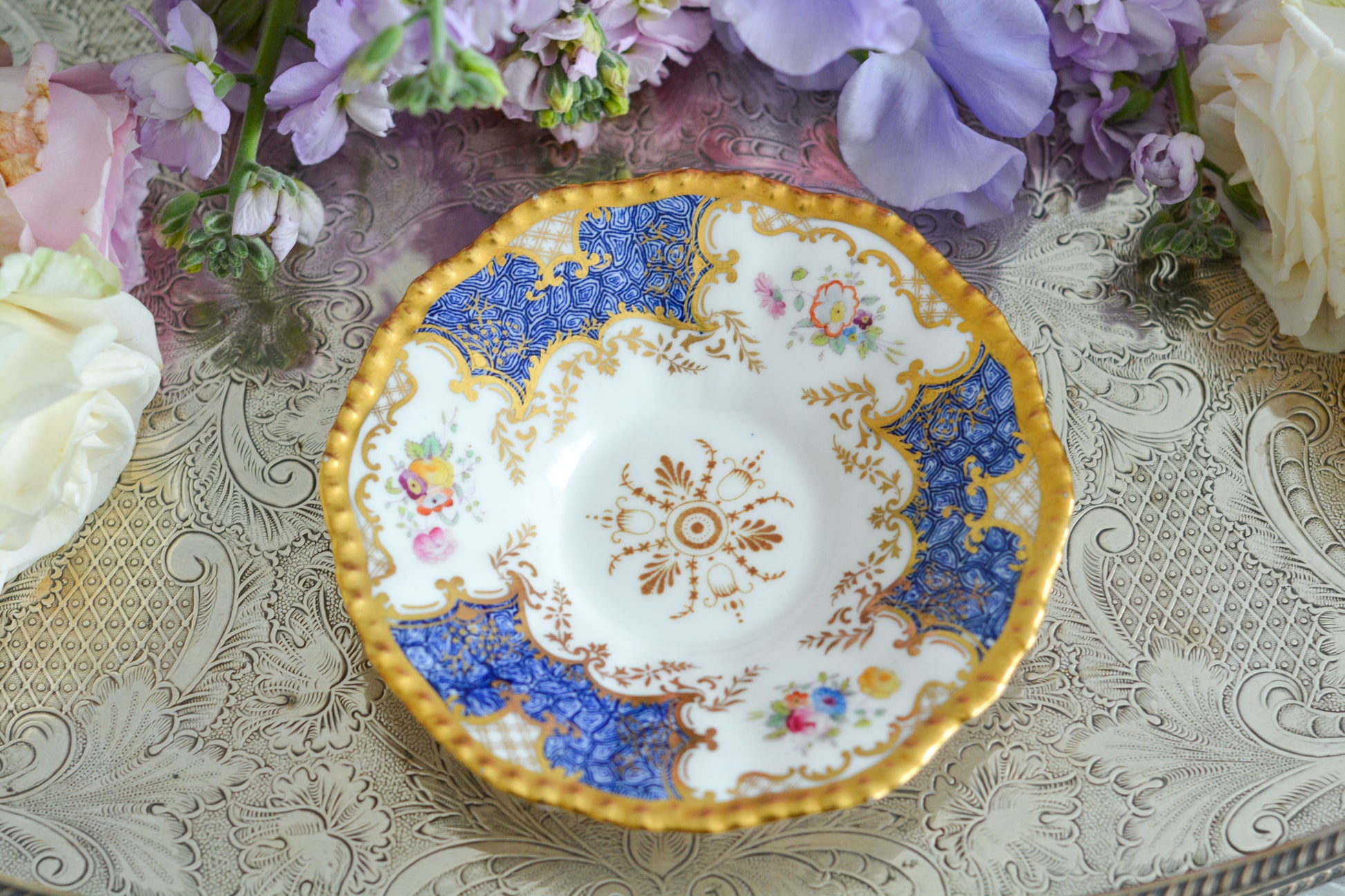 コールポートの人気シリーズ、バットウィングシリーズ。とても珍しい模様のデュオが入荷しました。鮮やかなブルーカラーの年輪のような模様がとても美しいお品です。カップのサイドにはエナメルのお花たちが描かれています。以前色違いの淡いグリーンをご紹介したことがあります。こちらは、カップに製造時にできたと思われる小さな穴があります。貫通はしていないのですが、そこだけ油薬がかかっていません。その穴付近にごく微細な貫入が1つあります。 その他は貫入もなく、金彩もとても綺麗に残っていて、キラキラと輝いています。特別なバットウィング。プレゼントにもご自身のご褒美にもぴったりなお品です。