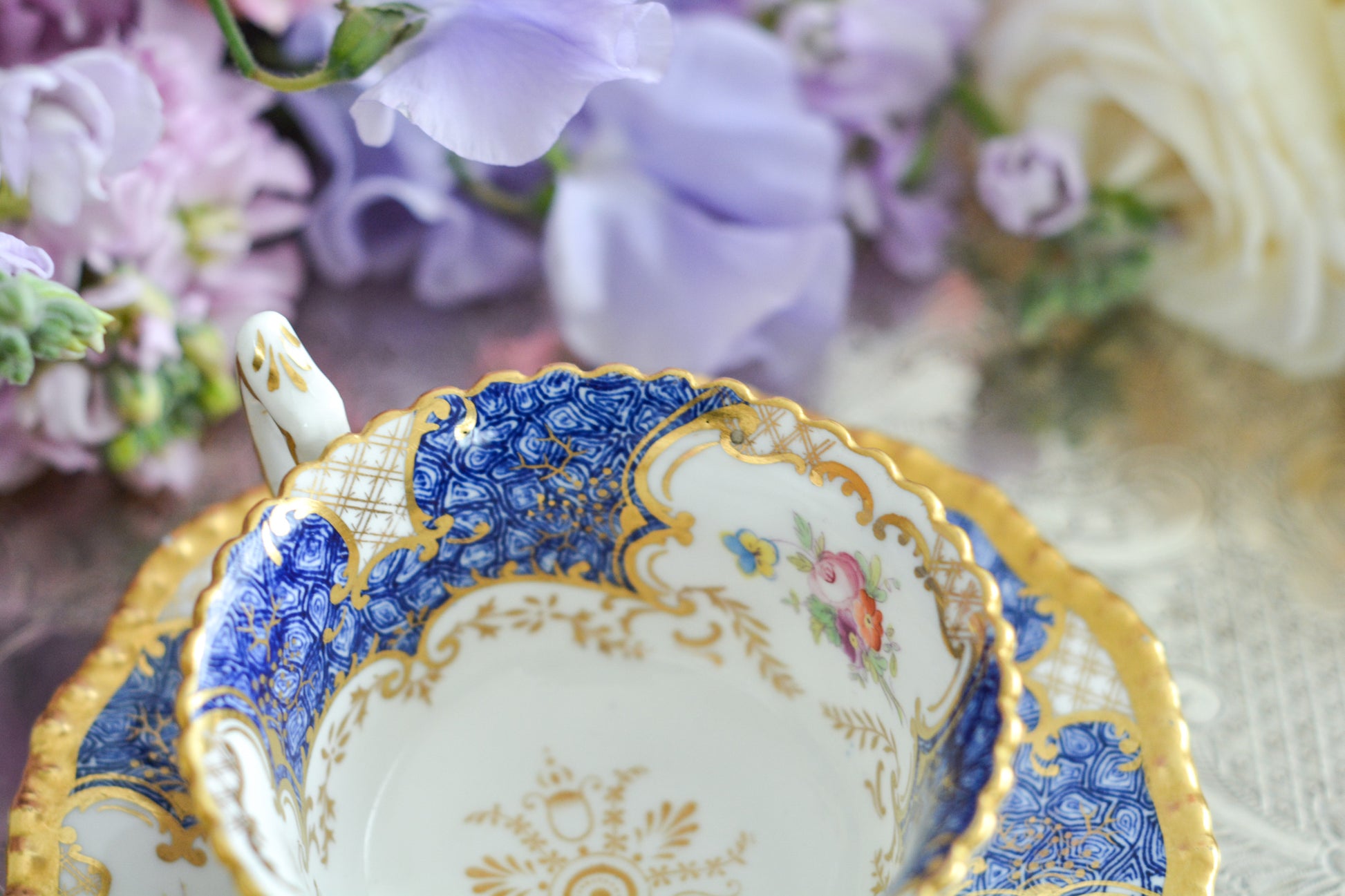 コールポートの人気シリーズ、バットウィングシリーズ。とても珍しい模様のデュオが入荷しました。鮮やかなブルーカラーの年輪のような模様がとても美しいお品です。カップのサイドにはエナメルのお花たちが描かれています。以前色違いの淡いグリーンをご紹介したことがあります。こちらは、カップに製造時にできたと思われる小さな穴があります。貫通はしていないのですが、そこだけ油薬がかかっていません。その穴付近にごく微細な貫入が1つあります。 その他は貫入もなく、金彩もとても綺麗に残っていて、キラキラと輝いています。特別なバットウィング。プレゼントにもご自身のご褒美にもぴったりなお品です。