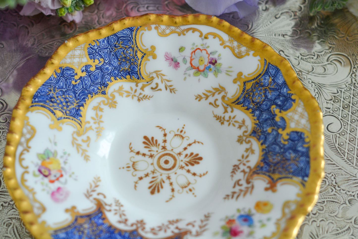 コールポートの人気シリーズ、バットウィングシリーズ。とても珍しい模様のデュオが入荷しました。鮮やかなブルーカラーの年輪のような模様がとても美しいお品です。カップのサイドにはエナメルのお花たちが描かれています。以前色違いの淡いグリーンをご紹介したことがあります。こちらは、カップに製造時にできたと思われる小さな穴があります。貫通はしていないのですが、そこだけ油薬がかかっていません。その穴付近にごく微細な貫入が1つあります。 その他は貫入もなく、金彩もとても綺麗に残っていて、キラキラと輝いています。特別なバットウィング。プレゼントにもご自身のご褒美にもぴったりなお品です。