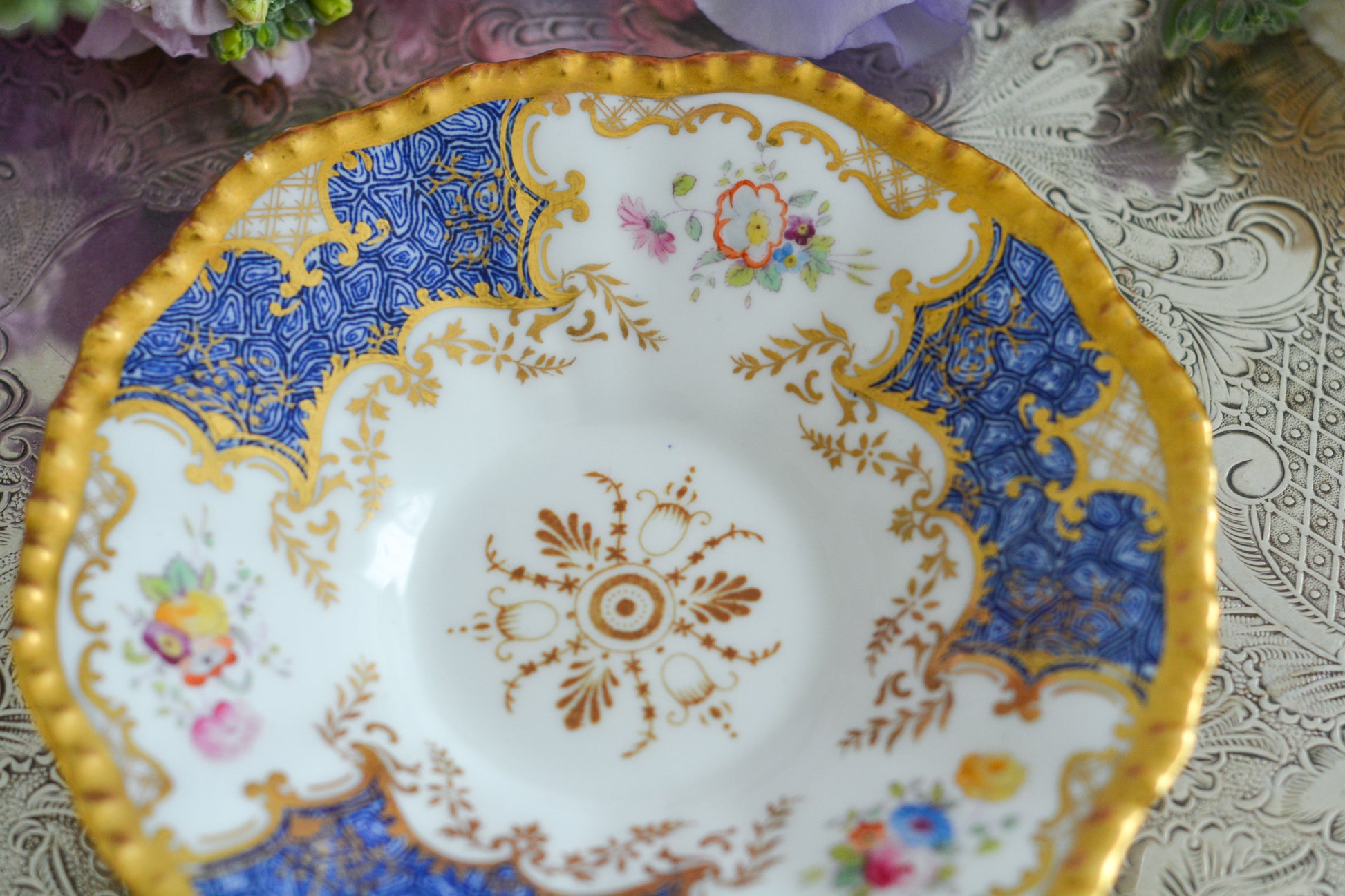 コールポートの人気シリーズ、バットウィングシリーズ。とても珍しい模様のデュオが入荷しました。鮮やかなブルーカラーの年輪のような模様がとても美しいお品です。カップのサイドにはエナメルのお花たちが描かれています。以前色違いの淡いグリーンをご紹介したことがあります。こちらは、カップに製造時にできたと思われる小さな穴があります。貫通はしていないのですが、そこだけ油薬がかかっていません。その穴付近にごく微細な貫入が1つあります。 その他は貫入もなく、金彩もとても綺麗に残っていて、キラキラと輝いています。特別なバットウィング。プレゼントにもご自身のご褒美にもぴったりなお品です。