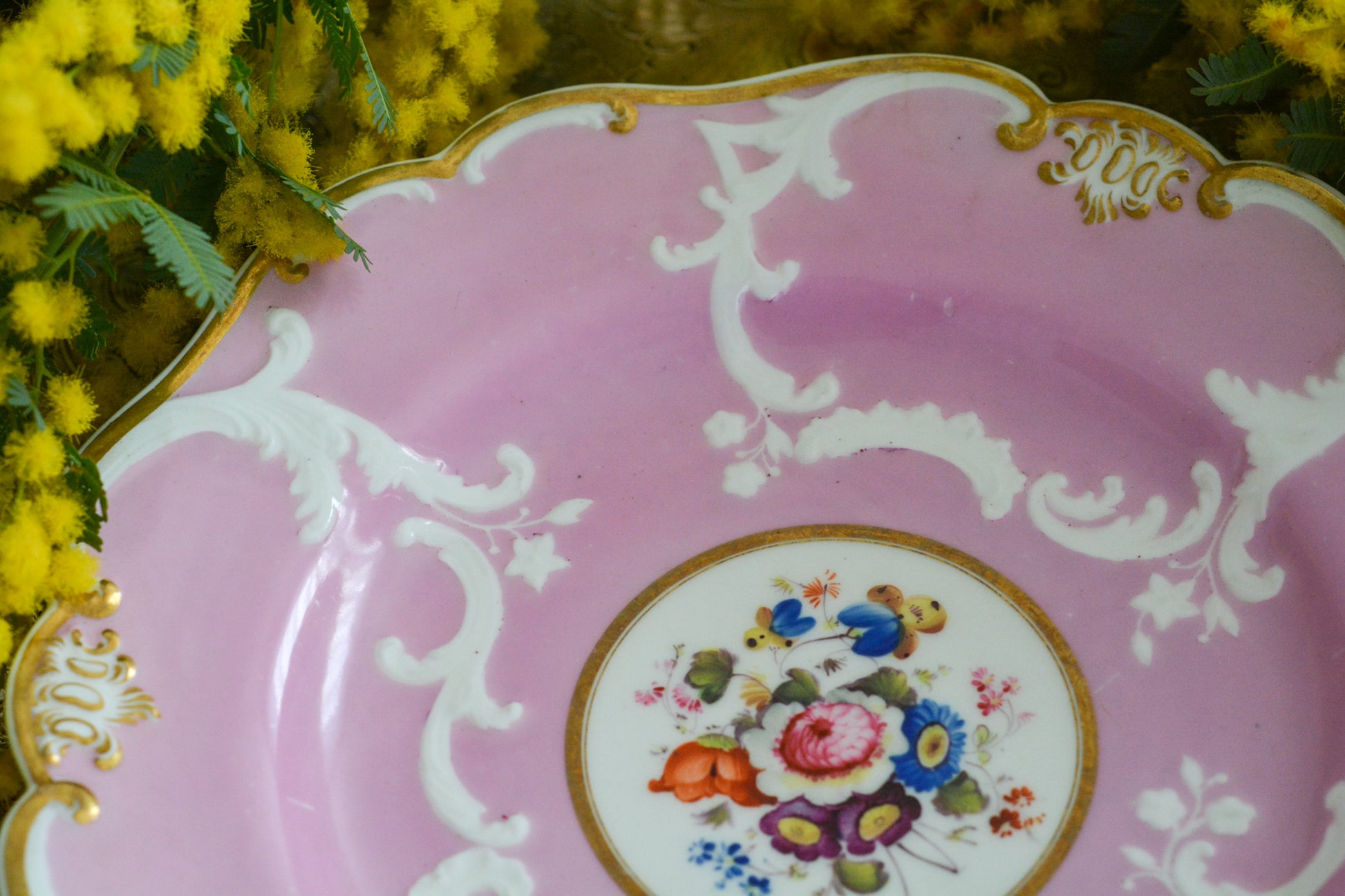 可愛らしいピンクカラーに中央にハンドペイントで丁寧に描かれたブーケの模様が美しいプレートです。エンボスの模様も優雅でチョコレートや小さな焼き菓子、パンどんなものを盛り付けても品よくまとまりそうです。一ヶ所小さなヘアラインがあるためお値打ち価格になっています。