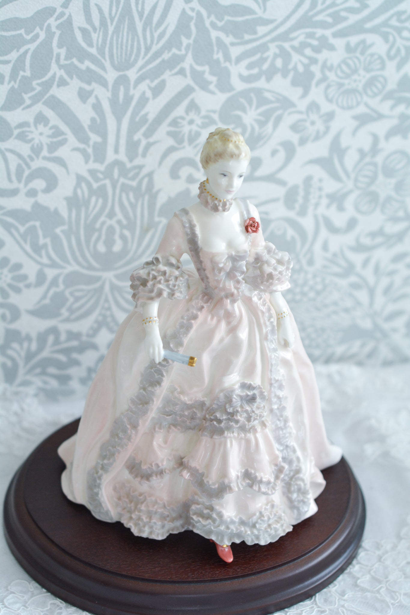 コールポートのポンパドール夫人の美しいフィギュリン。コールポートの中でも一番貴重で人気のフィギュリンではないでしょうか。美しいお顔にグレーとピンクの華やかなドレス。人気があるのも分かります。ポンパドール夫人はその美顔からフランスルイ15世の公式の愛妾となったのは有名な話。美顔だけでなく、頭もとてもよく政治にも積極的に関与しています。色々な側面を持ち合わせますが、芸術を愛し、その発展に大きな影響を与えました。ポンパドール夫人の時代はフランスを中心に優美なロココ様式が流行します。イギリスで1810年〜1830年代頃に流行したロココリバイバルはフランスのロココ様式の影響を受けてイギリスでロココ様式が再流行したものです。そんなポンパドール夫人のフィギュリンは、キャビネットに飾ってもティータイムにテーブルに置いてもどんなシーンでも、パッとスポットライトが当たったかのような存在感です。