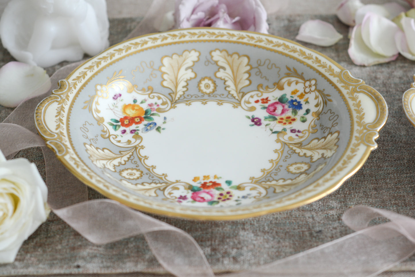 コウルドンのティファニーパターンのプレート。こちらは老舗ハロッズがオーダーしたもので、こちらはティファニーのスタンプはありませんが、柄はティファニーがコウルドンにオーダーしたパターンです。ティファニーらしい上品な絵柄がとても美しくでコウルドンの中でも人気のシリーズです。当時も人気があったのでしょう。いろいろな小売店がコウルドンにオーダーしています。ハンドルのついた深めのプレートはサービングプレートにもお使いいただきやすいと思います。