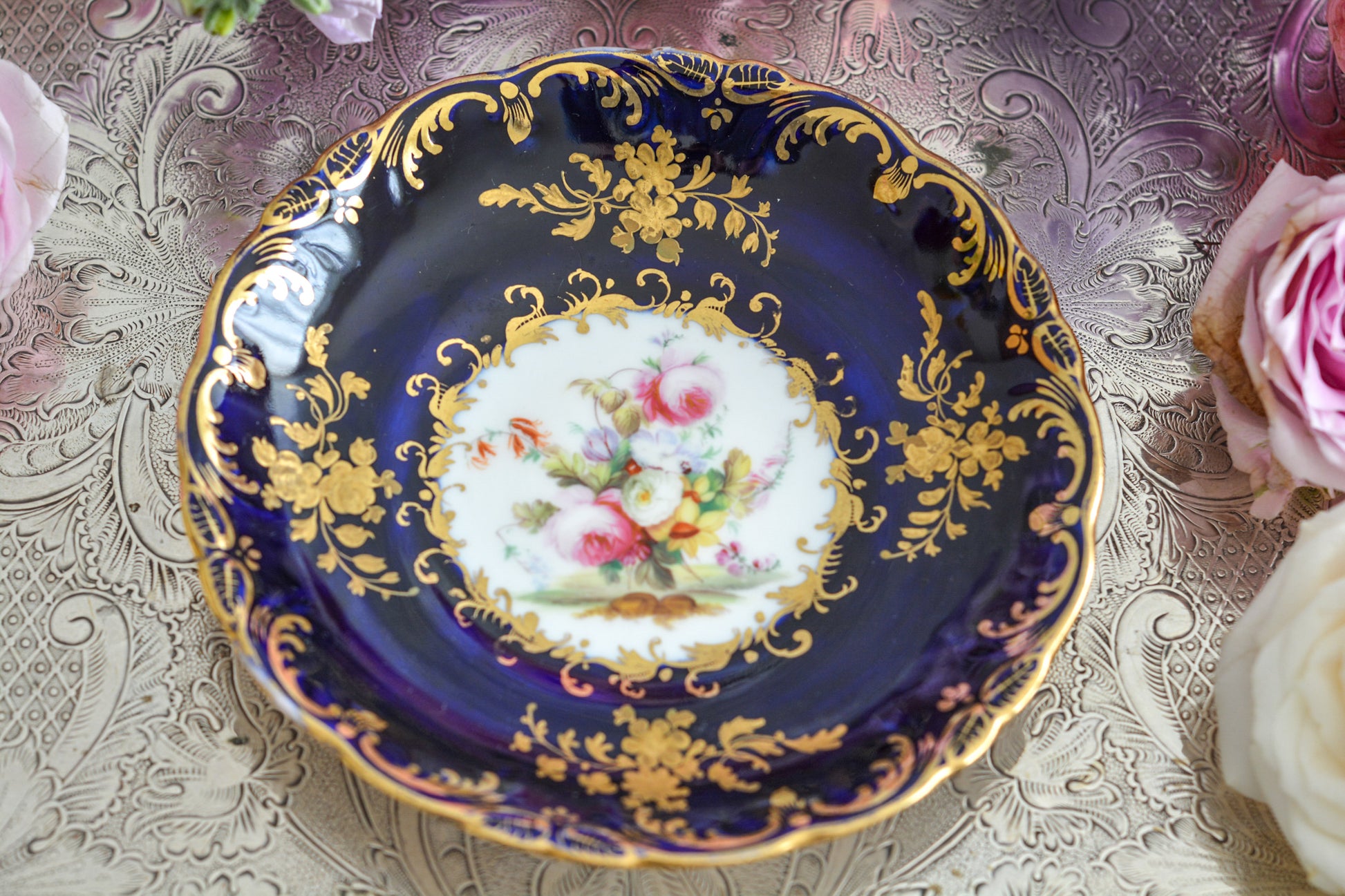 コールポートのロココリバイバル作品のアデレードシェイプ。とても優雅なシェイプで、ハンドペイントで描かれる花々は繊細でとても美しいです。いろいろなデザインが作られていて、シェイプは同じでも絵柄は少しずつ違います。こちらはコバルトブルーに金彩のお花模様が豪華なお品。アデレードシェイプは探すのにとても苦労しますが、見つけた時の喜びはとても大きいものです。金彩の薄れはありますが、貫入のないとても良い状態です。素敵なアデレードシェイプをぜひご覧ください。