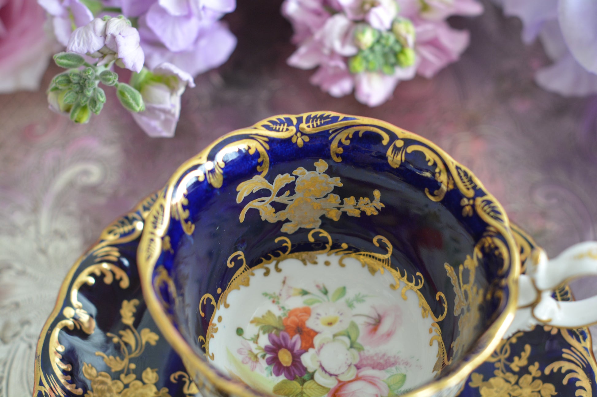 コールポートのロココリバイバル作品のアデレードシェイプ。とても優雅なシェイプで、ハンドペイントで描かれる花々は繊細でとても美しいです。いろいろなデザインが作られていて、シェイプは同じでも絵柄は少しずつ違います。こちらはコバルトブルーに金彩のお花模様が豪華なお品。アデレードシェイプは探すのにとても苦労しますが、見つけた時の喜びはとても大きいものです。金彩の薄れはありますが、貫入のないとても良い状態です。素敵なアデレードシェイプをぜひご覧ください。