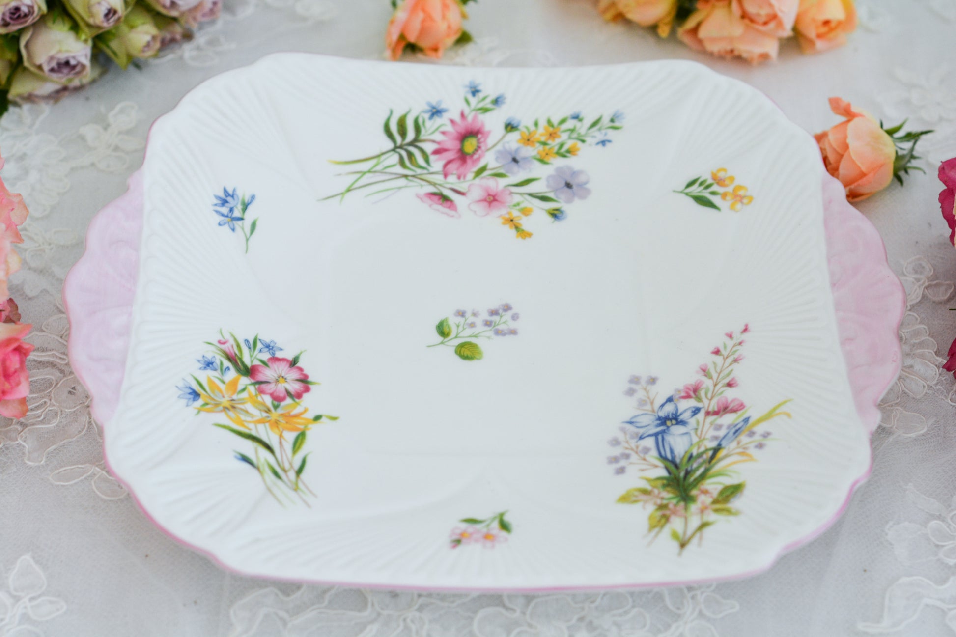シェリーのワイルドフラワーシリーズの可愛らしいB&Bプレート(ブレッド&バタープレート)。イギリスの色とりどりの野花が散りばめられていて、パステルピンクの縁取りとハンドルがとても可愛らしいお品です。B&Bプレートの「B&B」は「ブレッド&バター」のことでパンやお菓子を盛り付けるのに便利なプレートです。