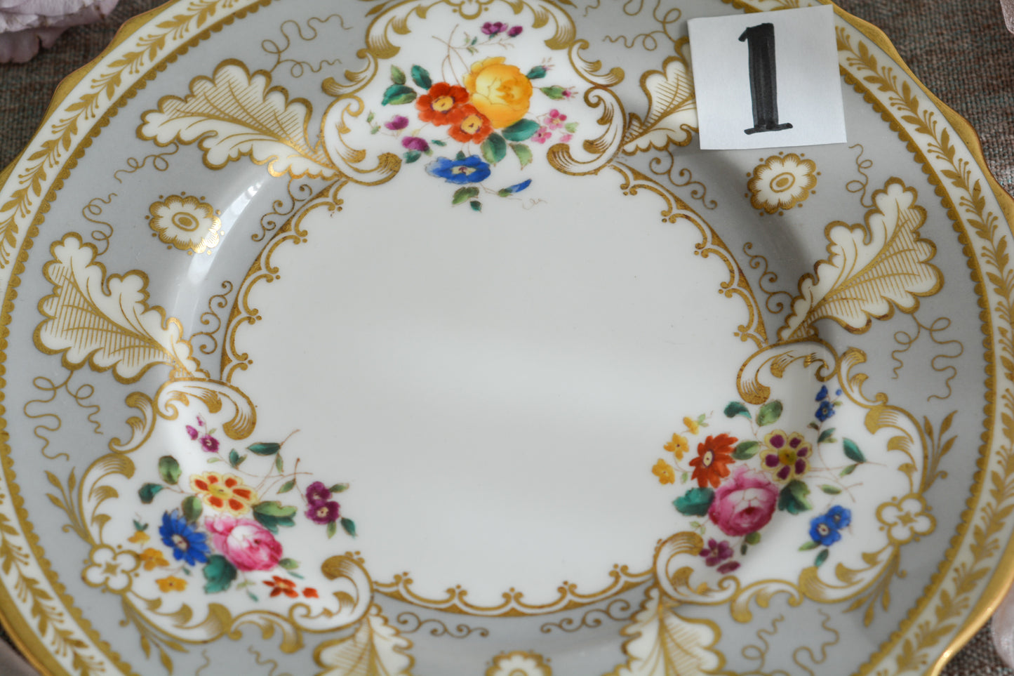 コウルドンのティファニーパターンの素敵なデザートプレートです。ハロッズがオーダーしたもので、ティファニーのスタンプはありませんが、柄はティファニーがコウルドンに特注したパターンです。ティファニーらしい上品な絵柄がとても美しくでコウルドンの中でも人気のシリーズです。当時も人気があったのでしょう。いろいろな小売店がこのパターンをオーダーしています。グレーカラーは柔らかい雰囲気で金彩との相性もいいです。とてもエレガントなプレートです。