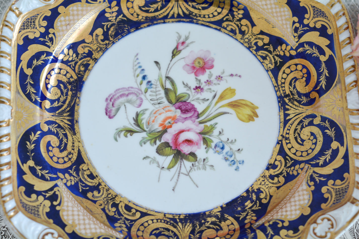 スポードのコバルトブルー地に豪華な金彩模様と手描きで描かれたブーケの模様が美しいプレートです。ちょっと珍しい形をしています。縁の縁飾りのような模様もとても素敵ですね。裏面にはバックスタンプではなく手描きでSpodeと記されています。とても豪華なプレートでキャビネットプレートとして飾ってもとても素敵だなと思います。