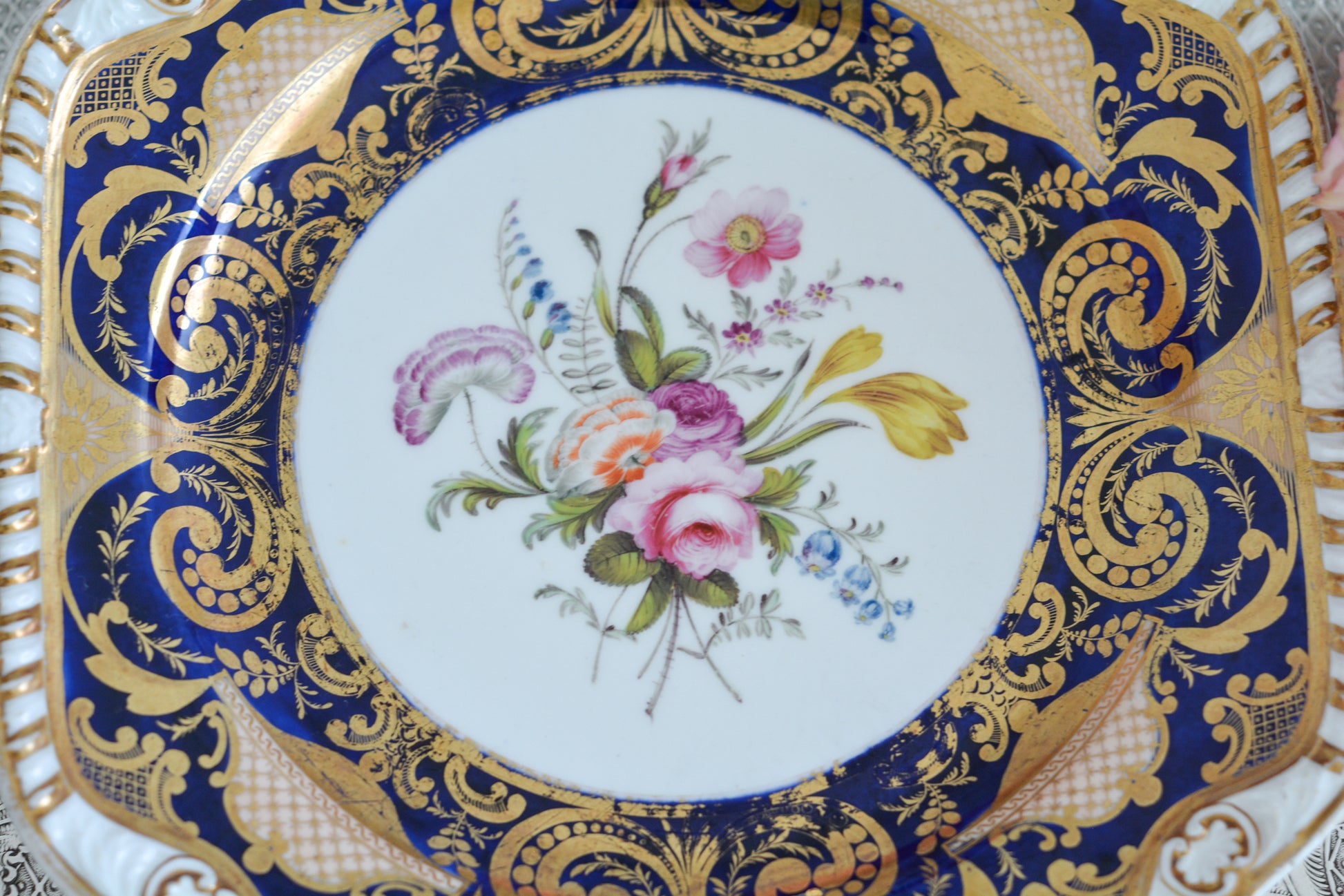 スポードのコバルトブルー地に豪華な金彩模様と手描きで描かれたブーケの模様が美しいプレートです。ちょっと珍しい形をしています。縁の縁飾りのような模様もとても素敵ですね。裏面にはバックスタンプではなく手描きでSpodeと記されています。とても豪華なプレートでキャビネットプレートとして飾ってもとても素敵だなと思います。