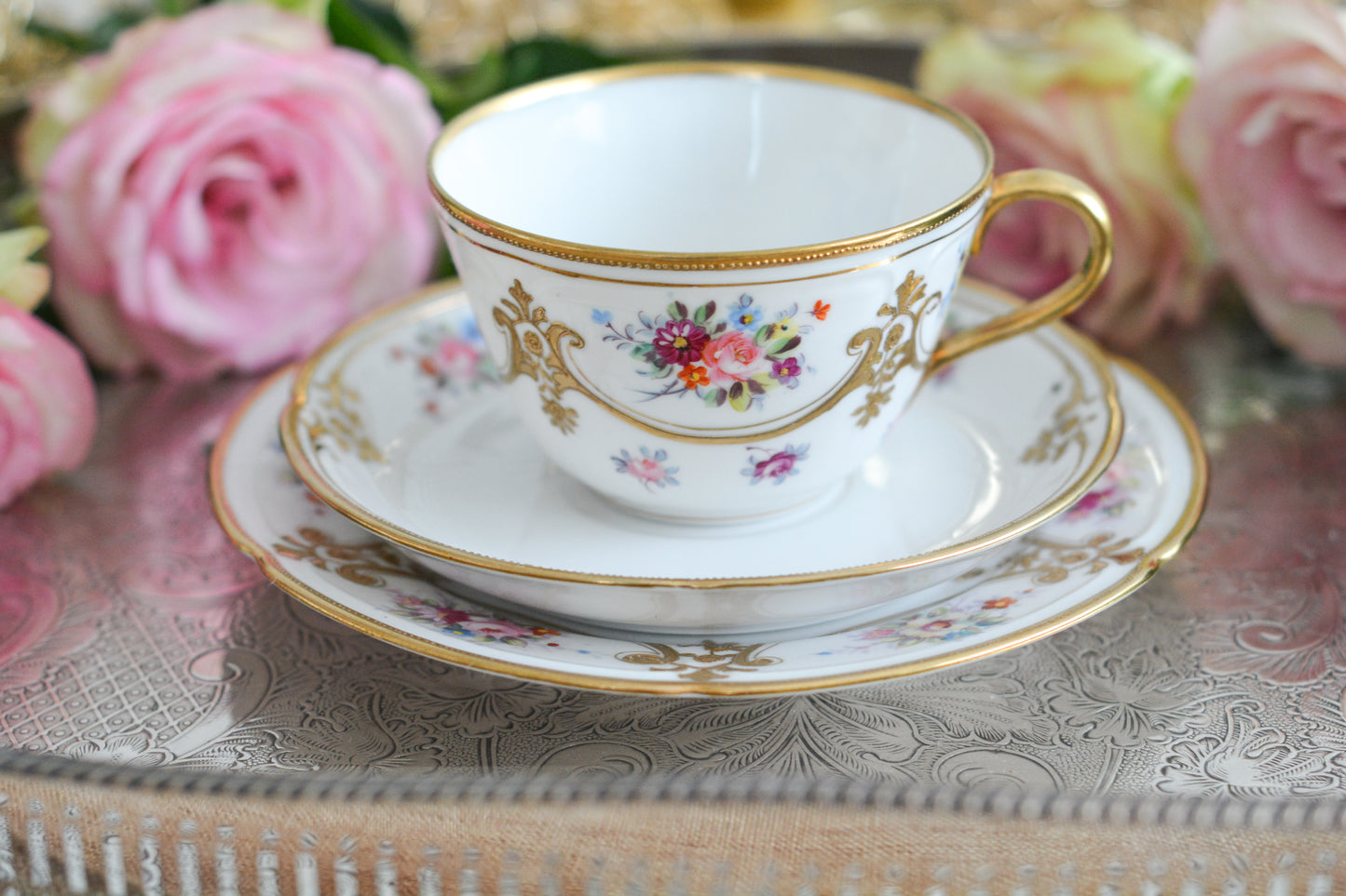 ノリタケの里帰り品のティートリオ。ハンドペイントで描かれた可愛らしいお花に金盛りの金彩の模様もとてもエレガントです。白磁がとても白く美しく気品を感じるお品。クリスマスはもちろんティータイムを華やかに盛り上げてくれるでしょう。
