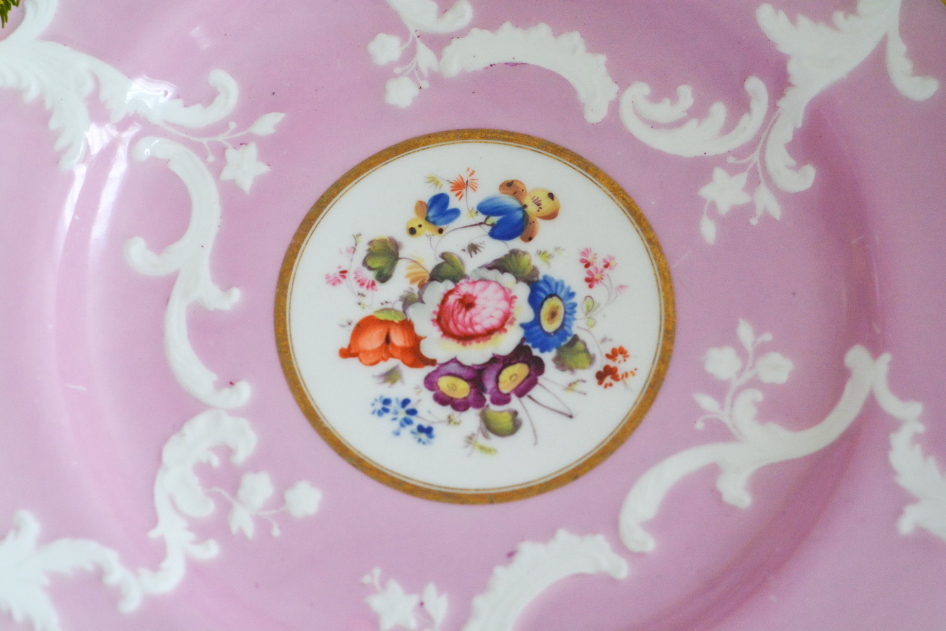 可愛らしいピンクカラーに中央にハンドペイントで丁寧に描かれたブーケの模様が美しいプレートです。エンボスの模様も優雅でチョコレートや小さな焼き菓子、パンどんなものを盛り付けても品よくまとまりそうです。一ヶ所小さなヘアラインがあるためお値打ち価格になっています。