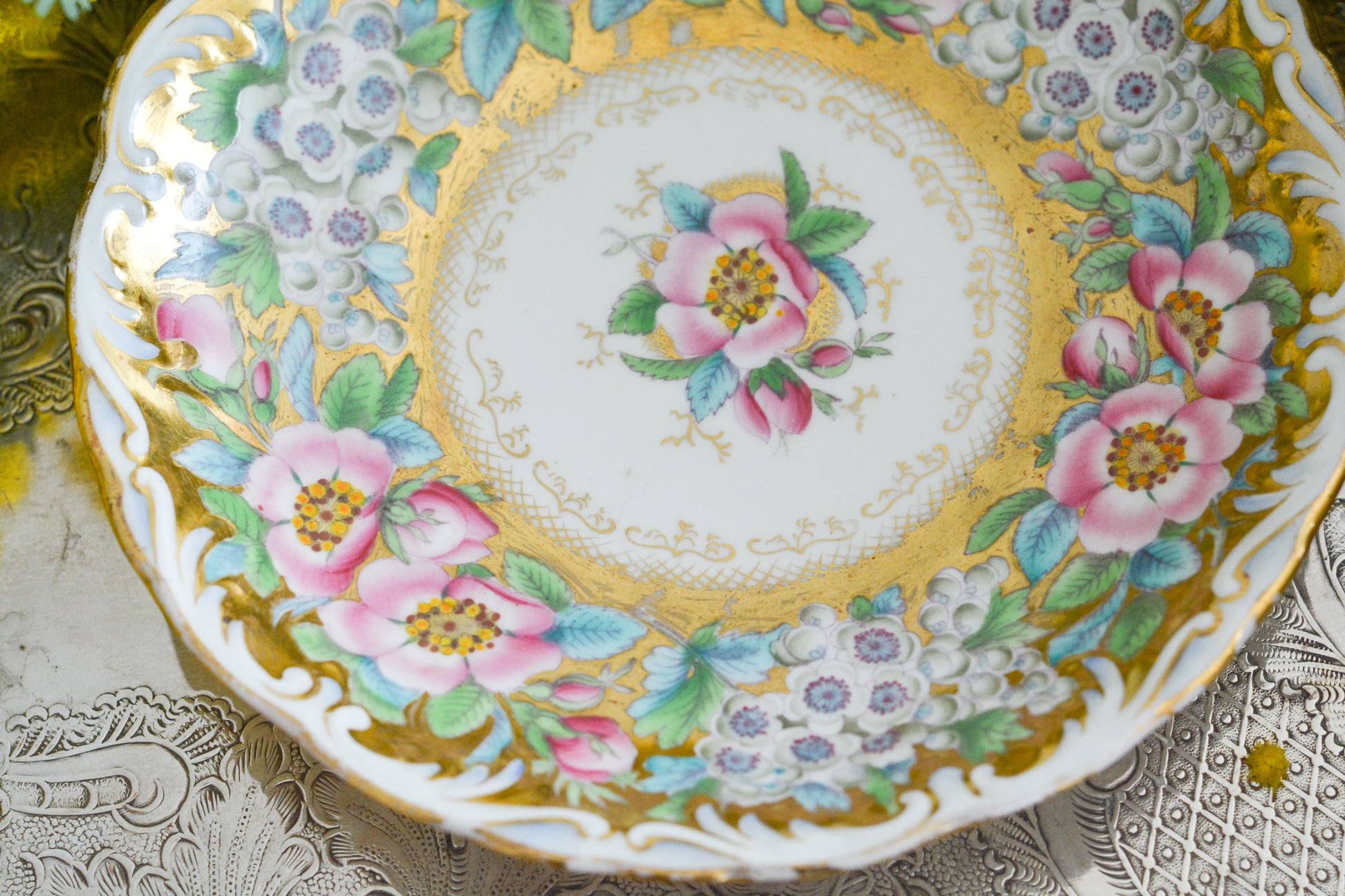 コールポートのロココリバイバル作品の人気のシェイプ、アデレードシェイプ。いろいろなデザインが作られていていますが、こちらのデザインは初めて見ました。ハンドペイントで描かれたお花は野ばらでしょうか?とても華やかなお品です。こちらは元々ティーカップとコーヒーカップ、ソーサーのセットだったと思われますが、コーヒーカップとソーサーのセットになっています。美しいお花がたくさん咲いたような美しいカップと共に春のティータイムをお楽しみください。