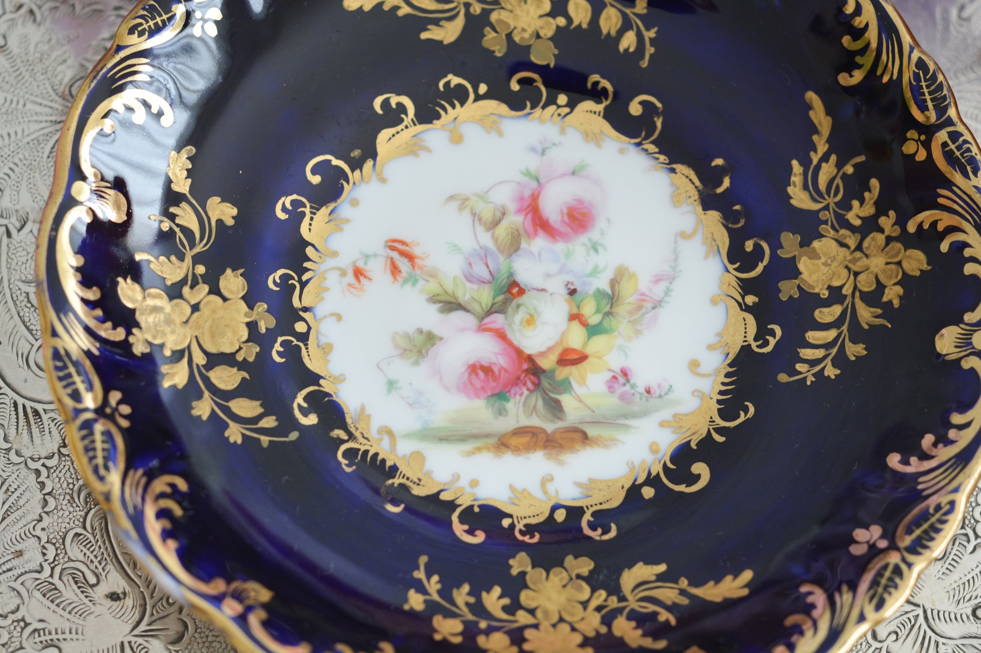 コールポートのロココリバイバル作品のアデレードシェイプ。とても優雅なシェイプで、ハンドペイントで描かれる花々は繊細でとても美しいです。いろいろなデザインが作られていて、シェイプは同じでも絵柄は少しずつ違います。こちらはコバルトブルーに金彩のお花模様が豪華なお品。アデレードシェイプは探すのにとても苦労しますが、見つけた時の喜びはとても大きいものです。金彩の薄れはありますが、貫入のないとても良い状態です。素敵なアデレードシェイプをぜひご覧ください。