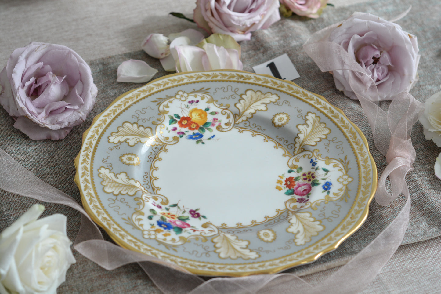 コウルドンのティファニーパターンの素敵なデザートプレートです。ハロッズがオーダーしたもので、ティファニーのスタンプはありませんが、柄はティファニーがコウルドンに特注したパターンです。ティファニーらしい上品な絵柄がとても美しくでコウルドンの中でも人気のシリーズです。当時も人気があったのでしょう。いろいろな小売店がこのパターンをオーダーしています。グレーカラーは柔らかい雰囲気で金彩との相性もいいです。とてもエレガントなプレートです。