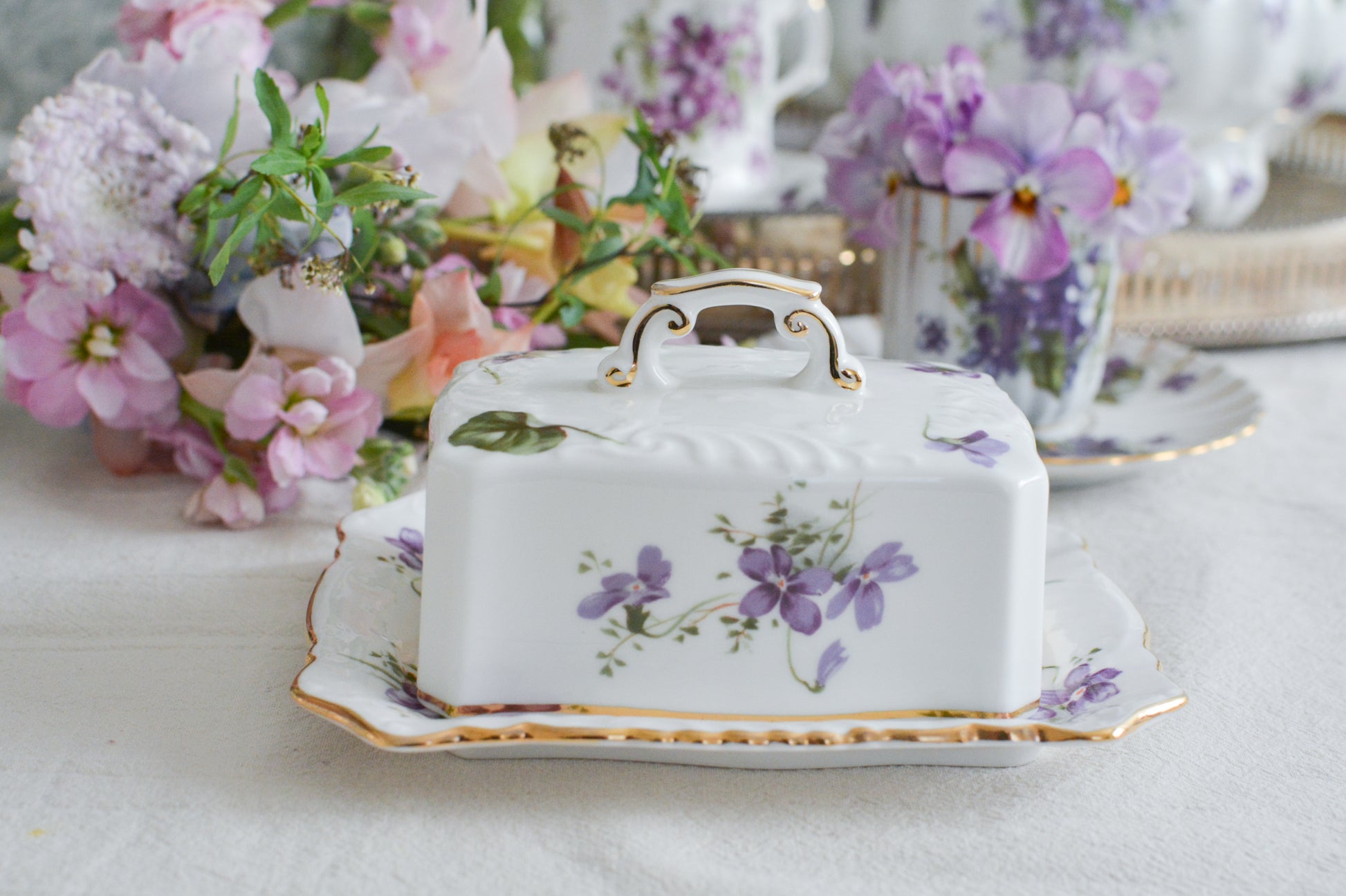 ハマースレイの人気シリーズ、ヴィクトリアンバイオレットシリーズ。珍しいバターディッシュです。お馴染みの可憐なすみれの模様が美しく、蓋の持ち手もハマースレイらしいとてもエレガントなデザイン。バターはもちろん、小さなお菓子を入れてゲストをおもてなししても素敵ですね。ティータイムを華やかに盛り上げてくれるアイテムです。