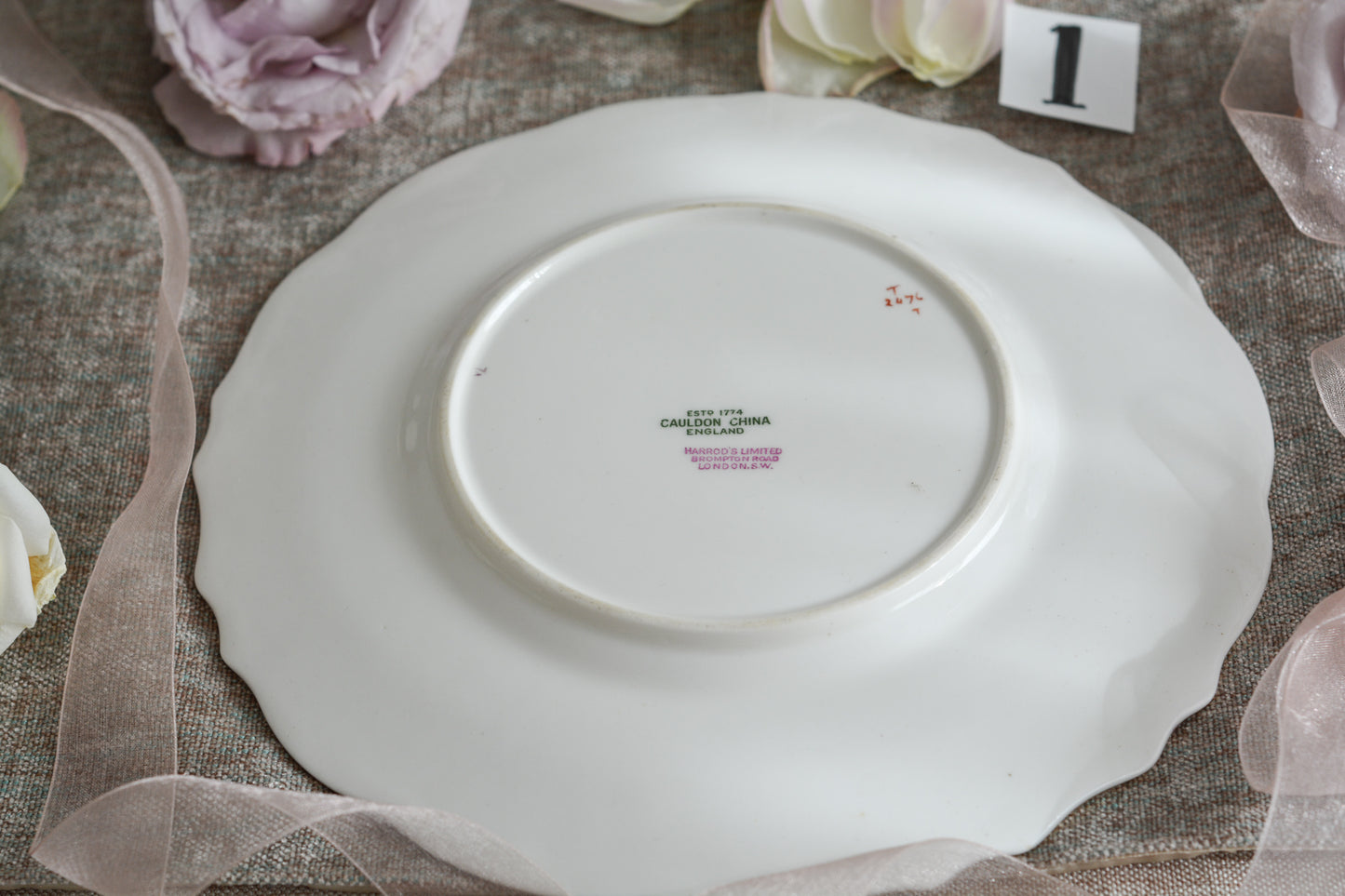 コウルドンのティファニーパターンの素敵なデザートプレートです。ハロッズがオーダーしたもので、ティファニーのスタンプはありませんが、柄はティファニーがコウルドンに特注したパターンです。ティファニーらしい上品な絵柄がとても美しくでコウルドンの中でも人気のシリーズです。当時も人気があったのでしょう。いろいろな小売店がこのパターンをオーダーしています。グレーカラーは柔らかい雰囲気で金彩との相性もいいです。とてもエレガントなプレートです。