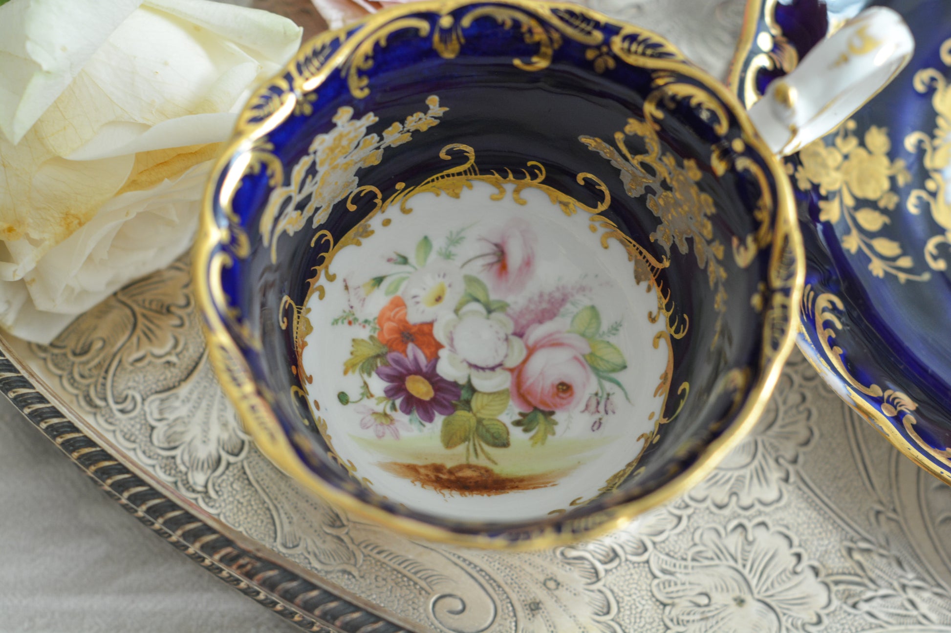コールポートのロココリバイバル作品のアデレードシェイプ。とても優雅なシェイプで、ハンドペイントで描かれる花々は繊細でとても美しいです。いろいろなデザインが作られていて、シェイプは同じでも絵柄は少しずつ違います。こちらはコバルトブルーに金彩のお花模様が豪華なお品。アデレードシェイプは探すのにとても苦労しますが、見つけた時の喜びはとても大きいものです。金彩の薄れはありますが、貫入のないとても良い状態です。素敵なアデレードシェイプをぜひご覧ください。