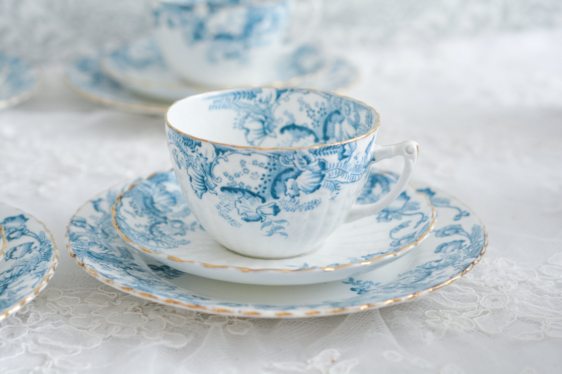 サミュエル・ラドフォードというメーカーの可愛らしいティートリオです。サミュエル・ラドフォードはスタッフォードシャーのメーカーで、1879年から1957年まで創業していました。こちらはブルーの転写模様がとても美しく地模様もとても可愛らしいお品です。同じパターンのミルクジャグ&シュガーボウル、色違いのデザートプレートも別で掲載しています。  こちらは1セットの価格です。全部で6セットあります。状態の良いものからお送りします。